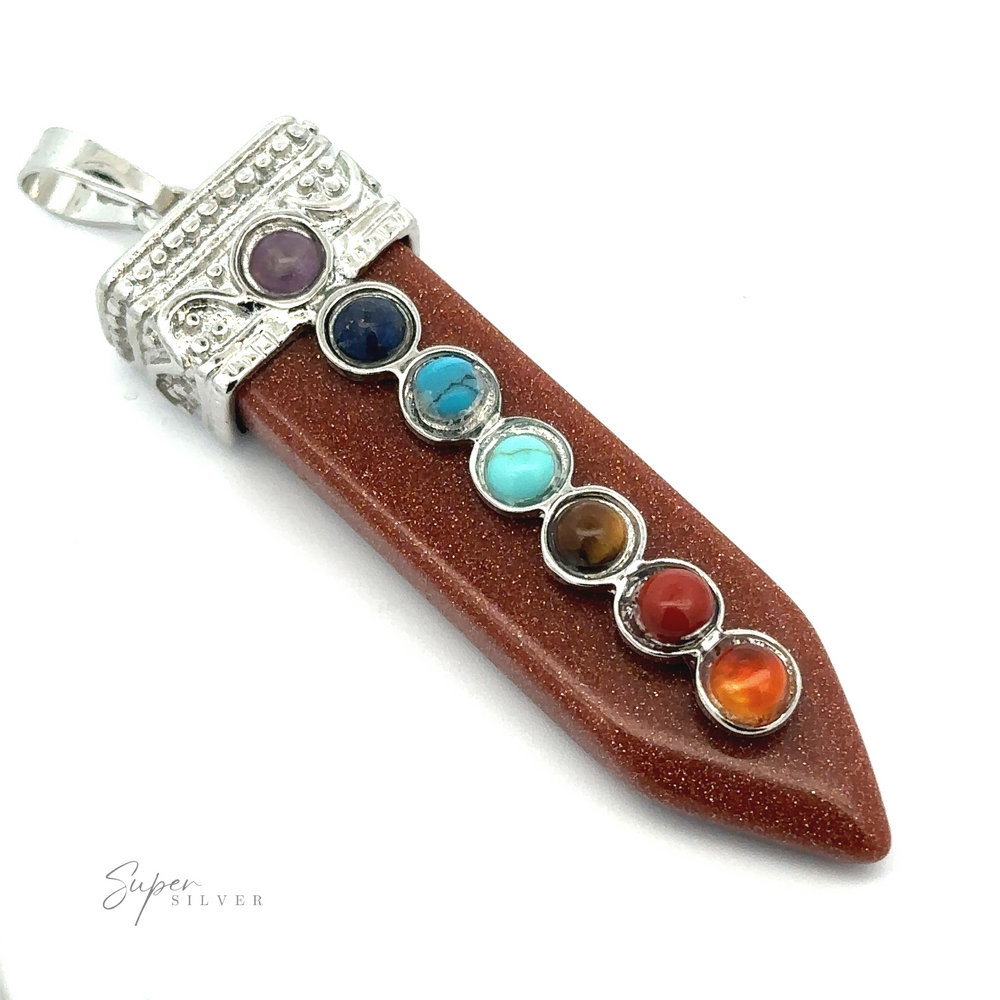 
                  
                    A silver-plated Obelisk Crystal Pendant with Small Chakra Stones featuring a brown gemstone point with seven smaller, multi-colored chakra stones set along its length.
                  
                