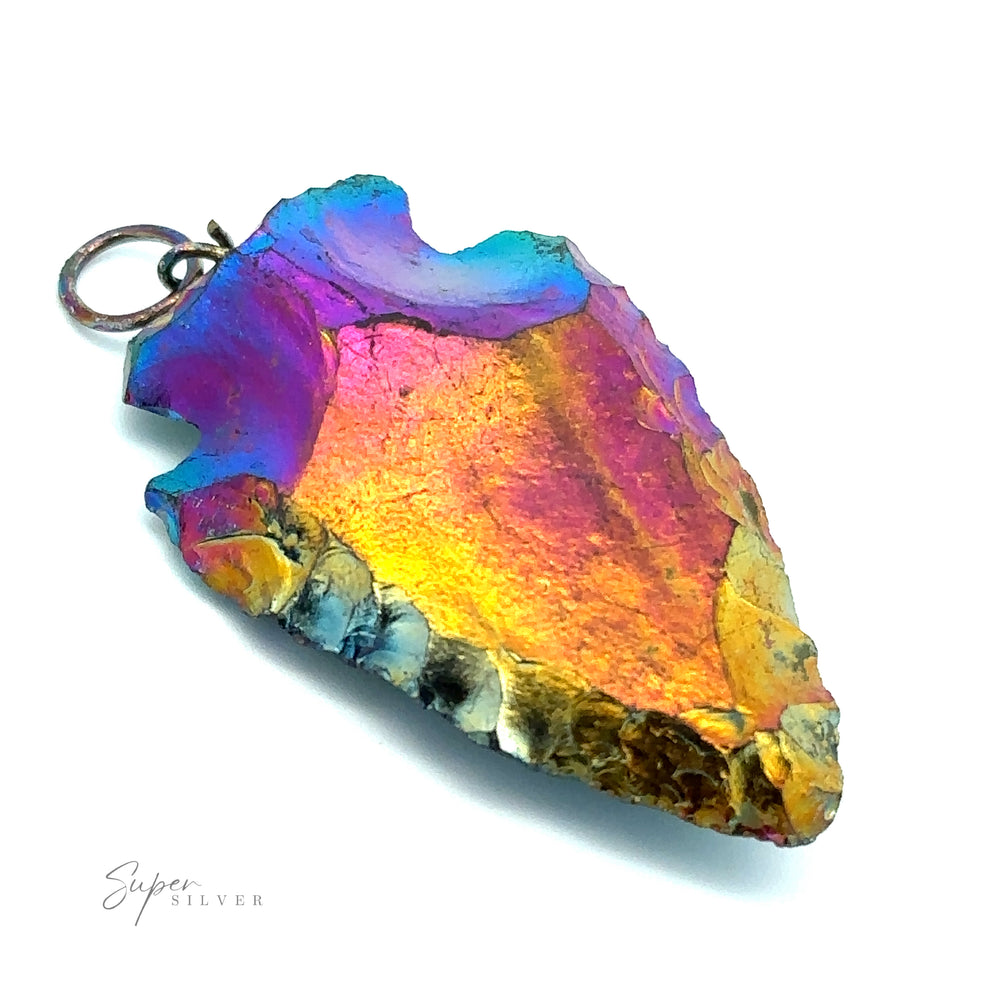
                  
                    A colorful Rainbow Hematite Arrowhead Pendant with iridescent shades of blue, purple, pink, and gold, attached to a small metal ring crafted from mixed metals, lays elegantly on a white surface.
                  
                