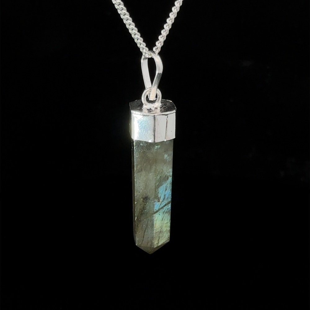 
                  
                    A Simple Gemstone Point Pendant featuring a long, hexagonal labradorite crystal with metallic hues, set in a silver-colored cap, hanging on a silver chain. This boho vibe crystal pendant emanates mystical charm, perfect for any free spirit.
                  
                