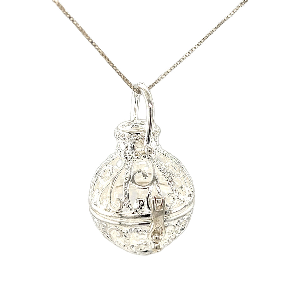 An ornate Super Silver Filigree Cage Pendant on a chain with a boho vibe.