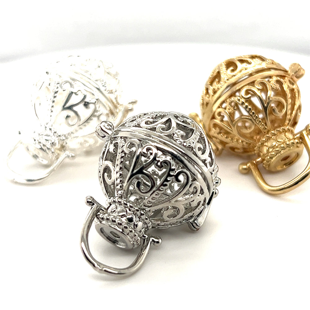 
                  
                    Three Super Silver Filigree Cage Pendants on a white surface, emanating a boho vibe.
                  
                