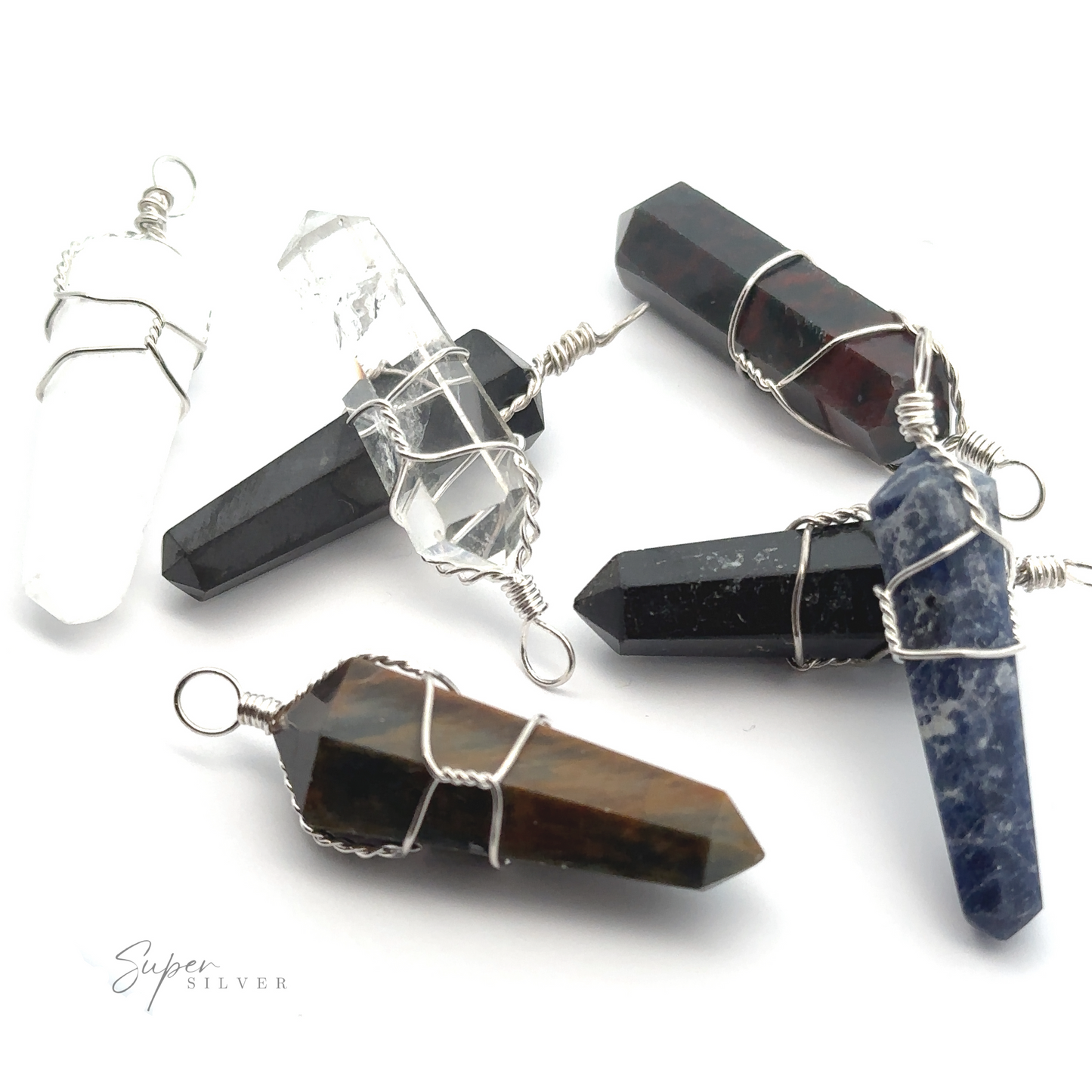 
                  
                    Five Wire Wrapped Stone Pendants, including Quartz and Bloodstone, in various colors and types, wrapped with wire and laid out in a scattered arrangement.
                  
                