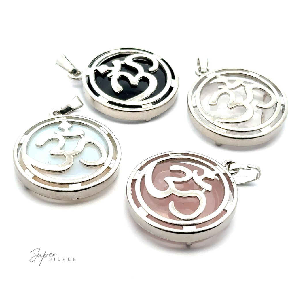Four Om Pendants, each featuring a silver plated Om symbol against backgrounds of black, white, pink, and light blue. Arranged on a white surface with 