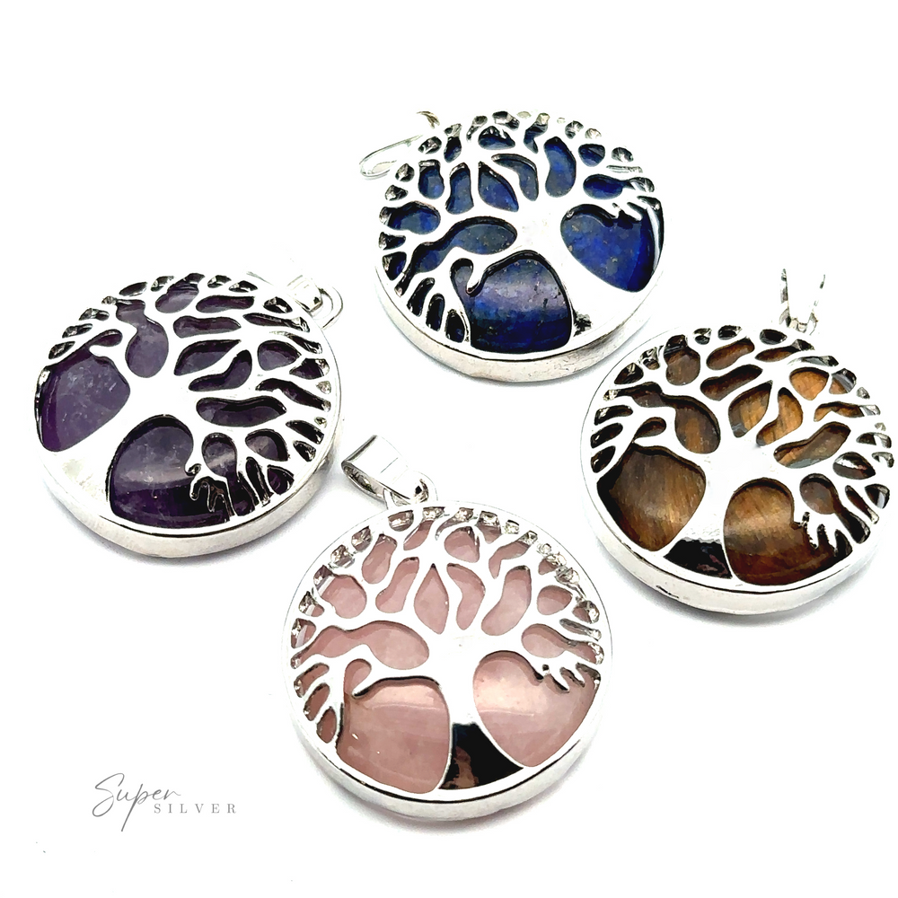 Four silver-plated Tree of Life Pendants, each featuring a unique gemstone background in blue, purple, pink, and brown.