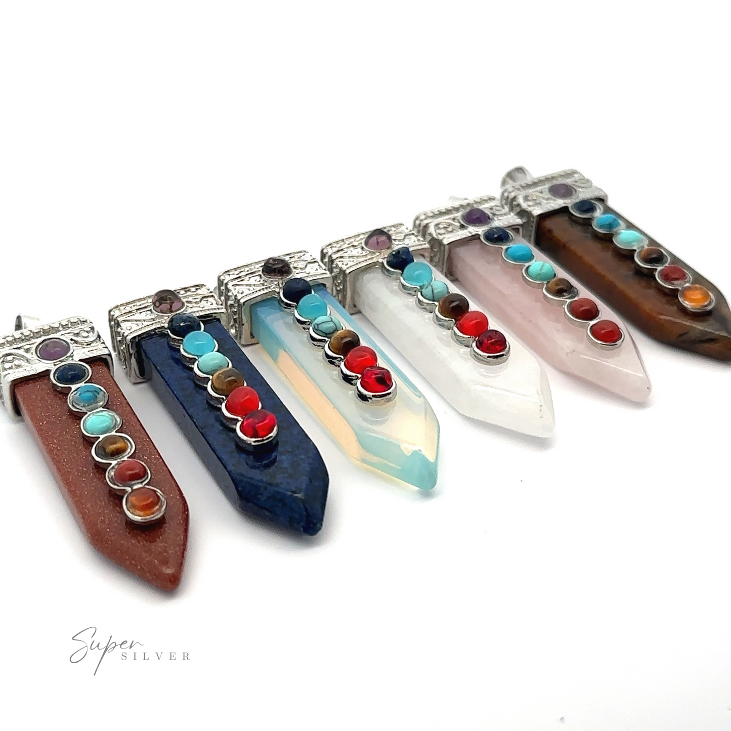 
                  
                    A row of six Obelisk Crystal Pendants with Small Chakra Stones with silver caps, each featuring round colorful stones. The gemstones, which could double as chakra stones, include brown, blue, white, pink, and striped varieties, arranged side by side on a white background.
                  
                
