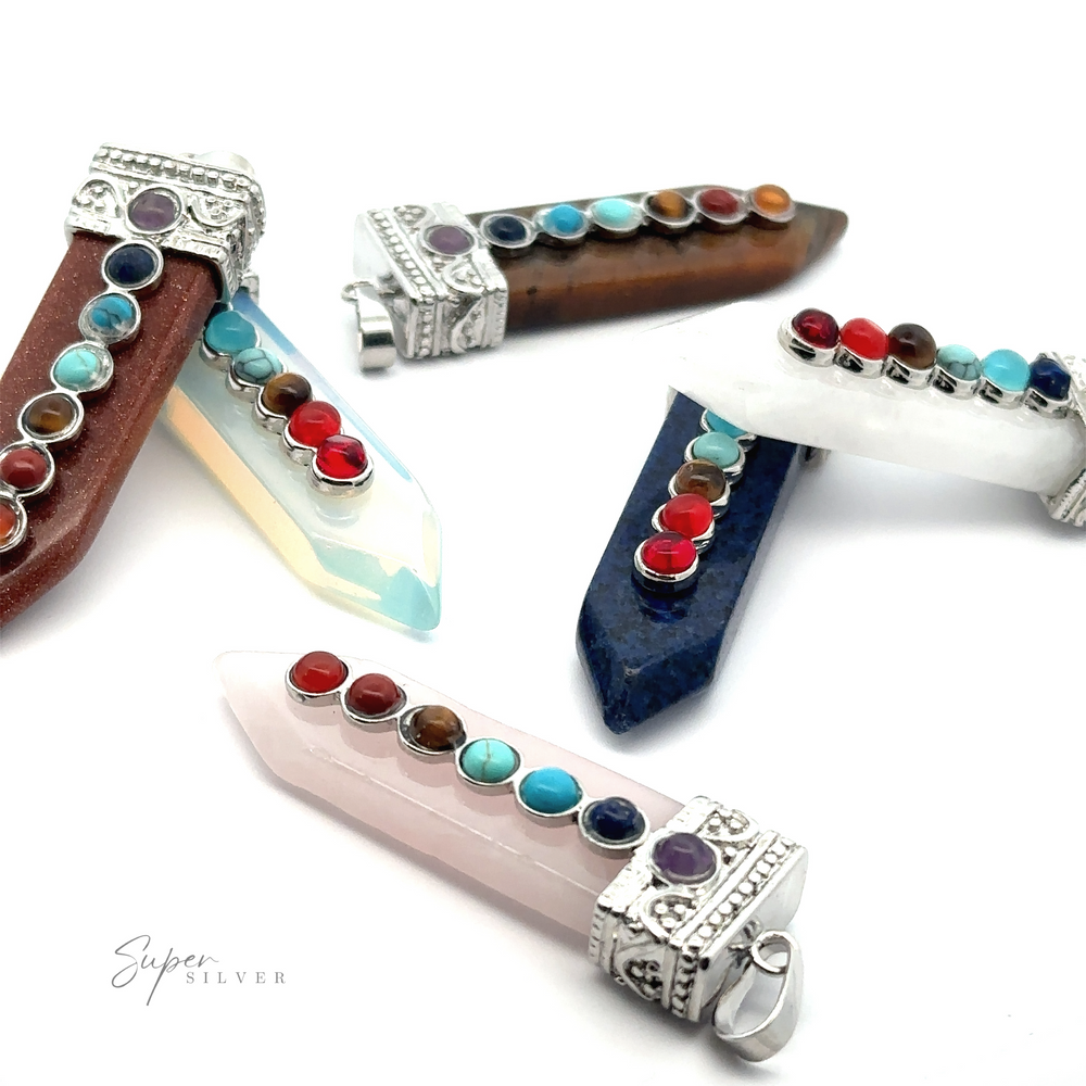 A variety of **Obelisk Crystal Pendants with Small Chakra Stones**, including striking obelisk pendants and chakra stones, displayed against a white background.