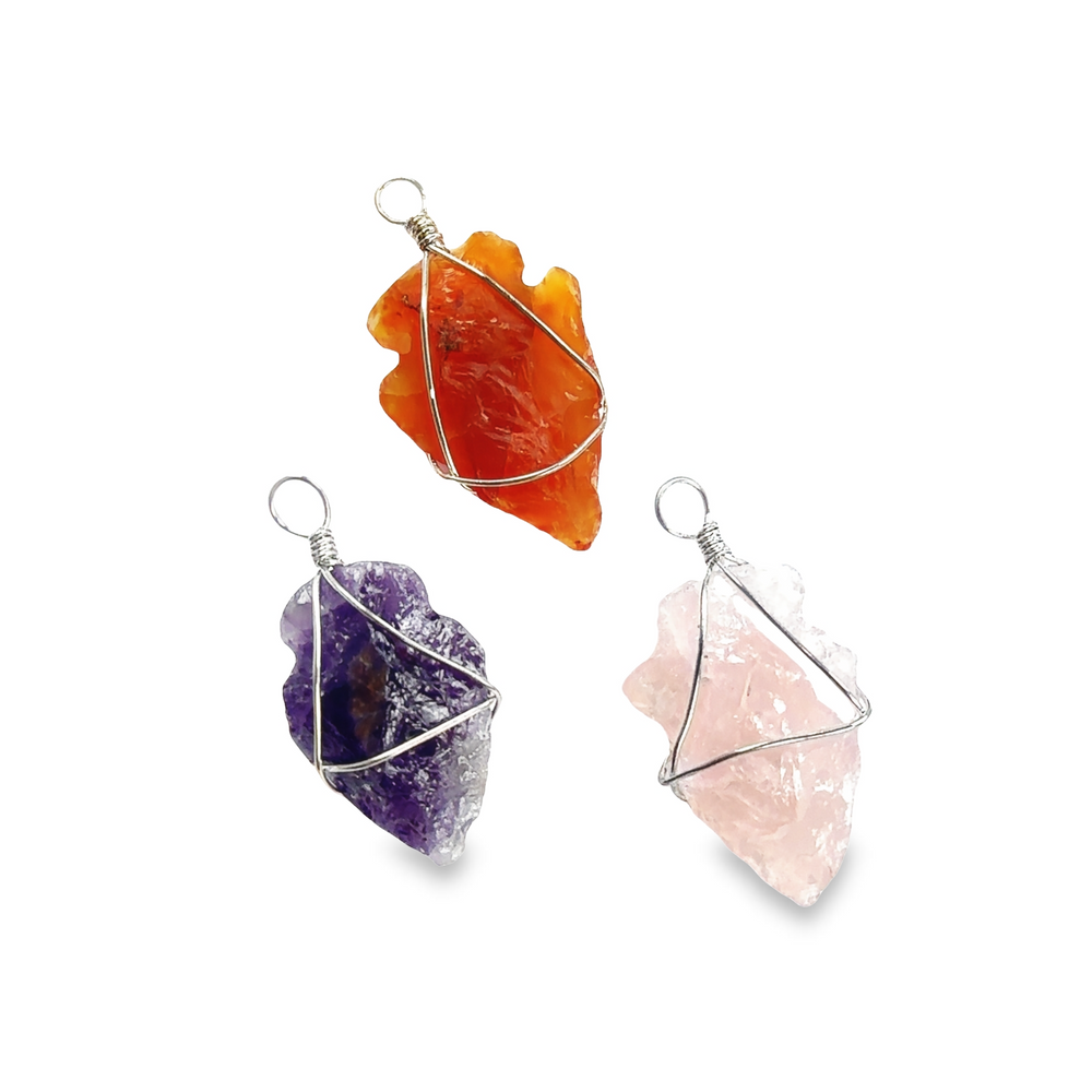 Three Super Silver symbolism-infused Wire Wrapped Stone Arrowhead Pendants in varying styles, adorned with different colored crystals on a serene white background.