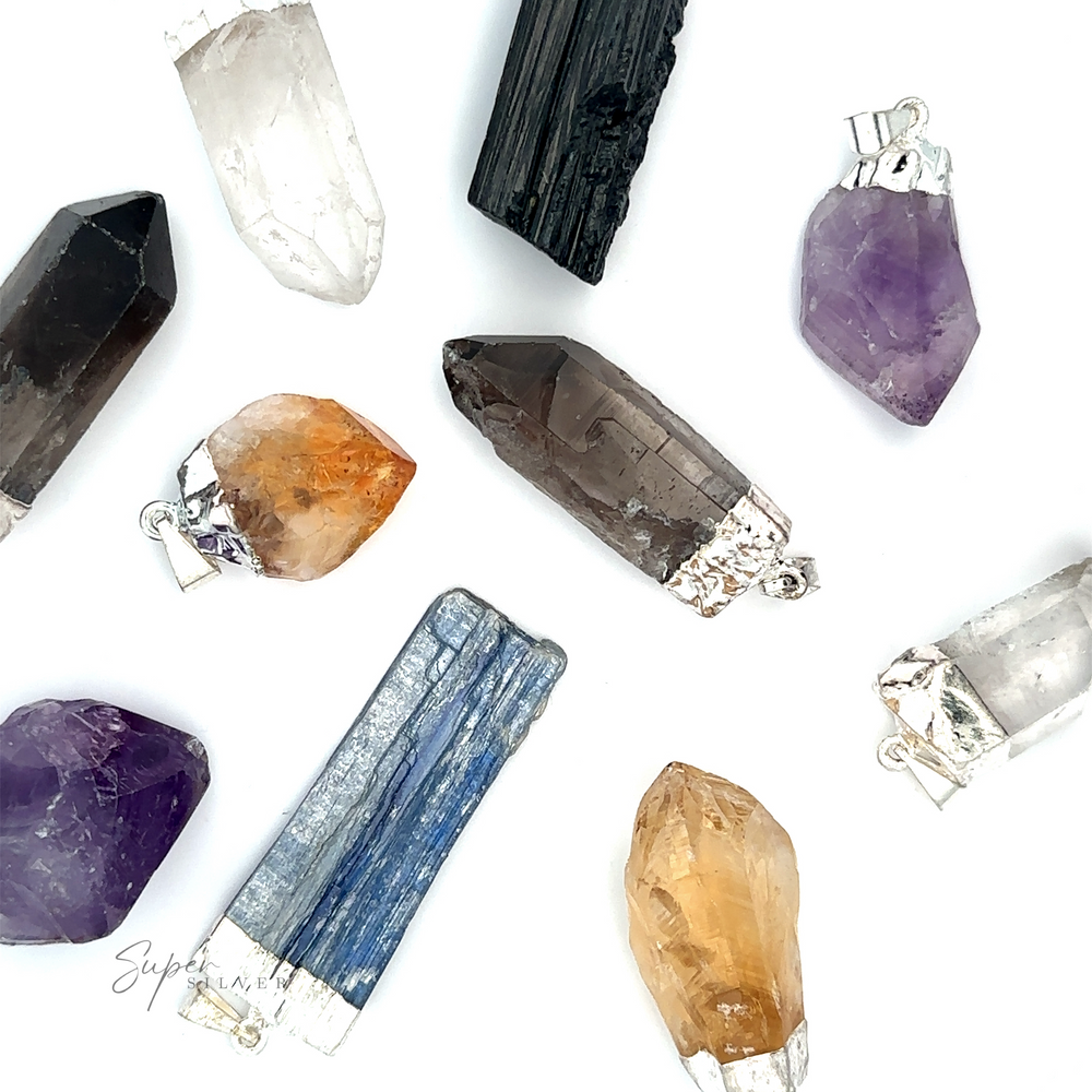 An assortment of Raw Crystal Pendant With Silver Cap in various colors and shapes, including raw crystal designs, arranged on a white background.