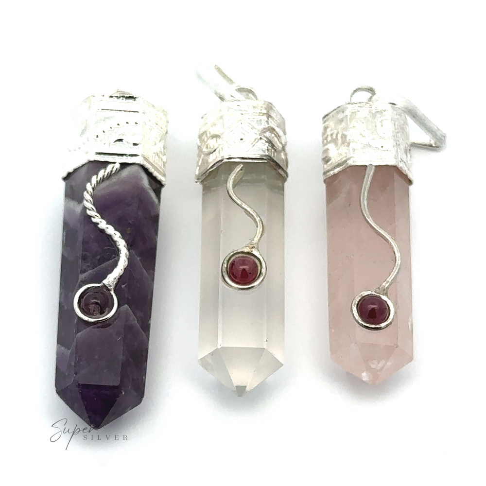 
                  
                    Three Crystal Pendants with Decorative Bails, each featuring a small garnet detail at the center. The crystals are purple, clear, and rose quartz.
                  
                