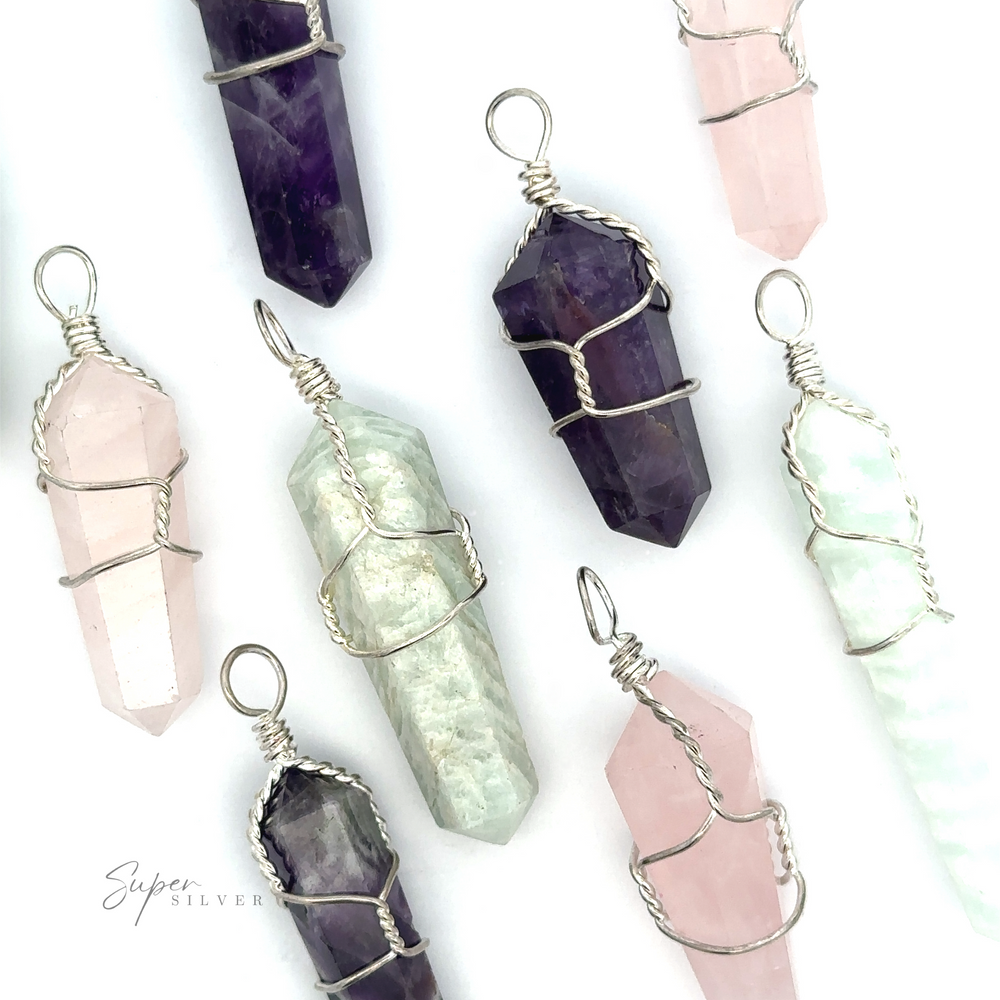 A collection of Wire-Wrapped Stone Pendants in various colors, including purple, pink, and green. Each genuine stone pendant is wrapped with silver wire and has a loop at the top for attaching to a chain.