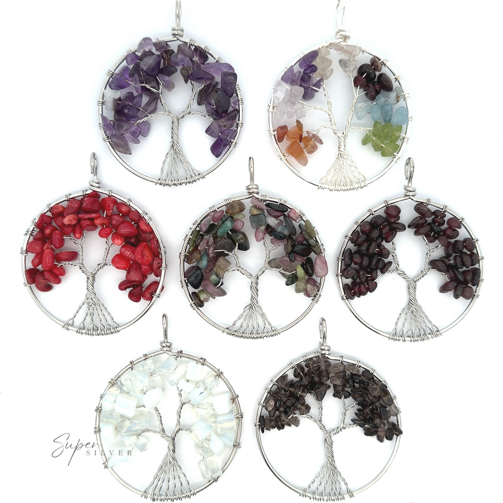Seven Wire Wrapped Tree of Life Pendants are displayed, each featuring vibrant gemstones in different colors: purple, clear, multicolored, red, dark green, white, and dark red. These stunning pieces showcase the elegance of mixed metals and intricate craftsmanship.