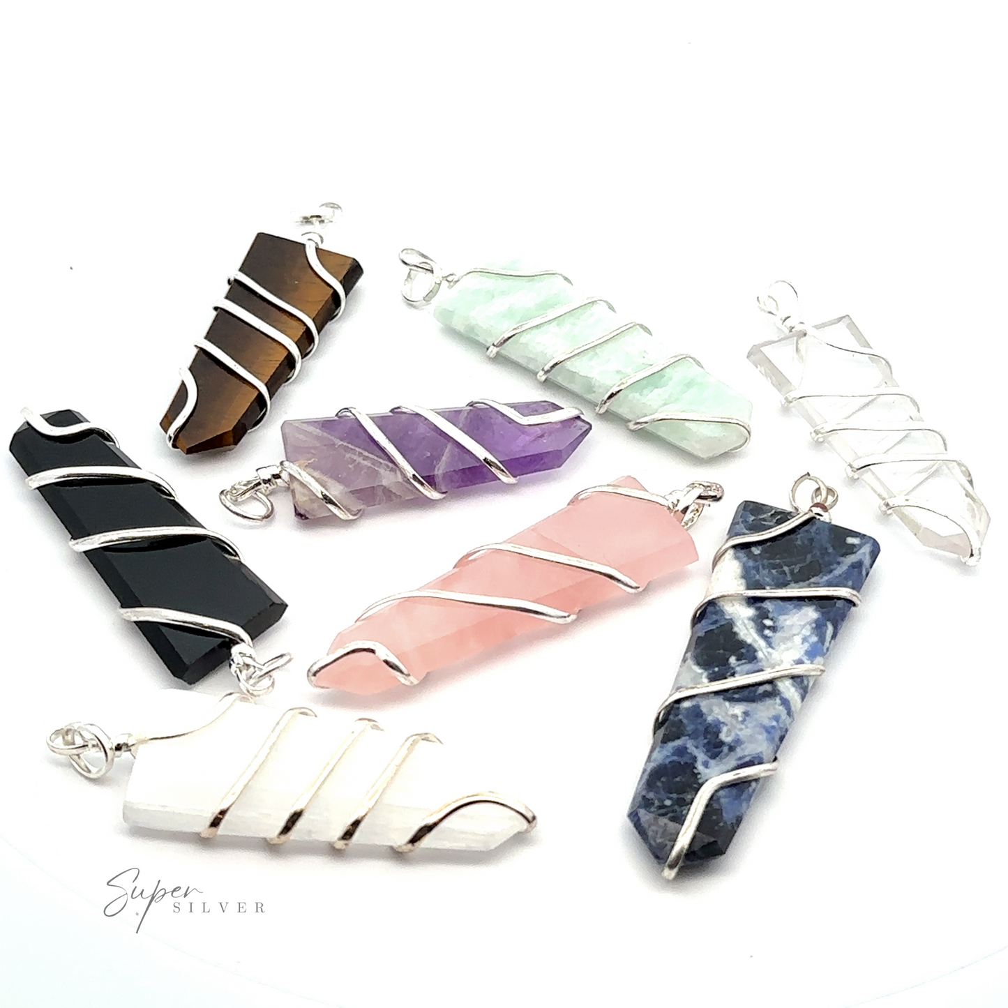 
                  
                    Seven stunning crystal pendants wrapped in silver wire are displayed on a white background. The gemstone jewelry varies in color, including black, brown, white, green, purple, pink, and blue. Each Wire Wrapped Slab Pendant showcases the natural beauty of its unique stone slab pendant.
                  
                