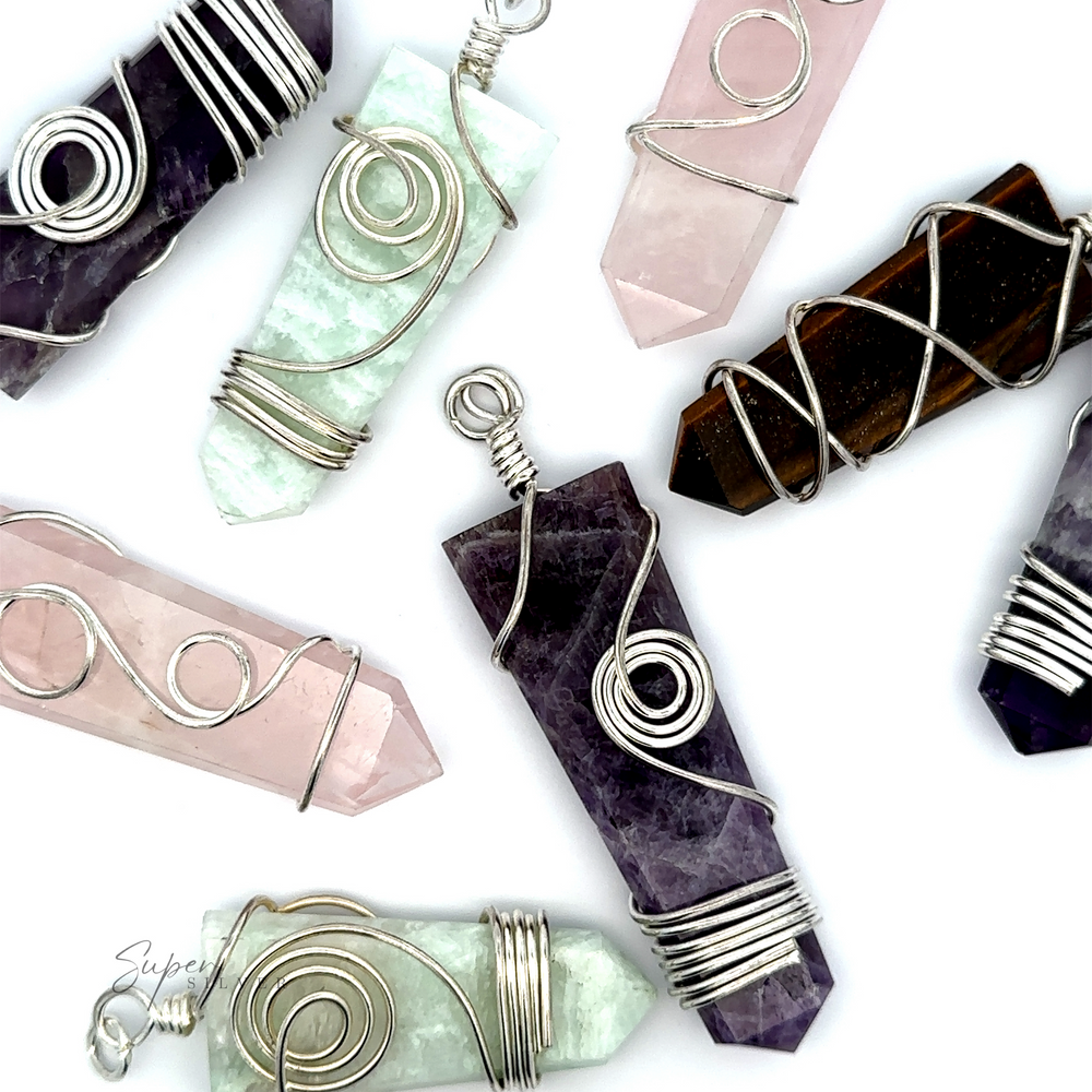 A close-up of various colored Stone Slab Pendants with Wire Wrapping on a white background, showcasing the intricate beauty of mixed metals in wire wrapped jewelry and featuring stunning amethyst, rose quartz, and other exquisite gemstone pendants.