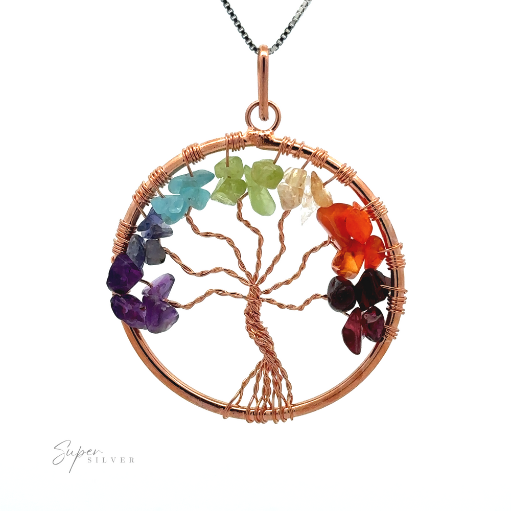 
                  
                    A Wire-Wrapped Chakra Tree of Life Pendant made of copper wire, adorned with multicolored gemstone chips representing leaves, hangs on a silver chain. This exquisite wire-wrapped design features chakra stones that add spiritual significance to its beauty.
                  
                