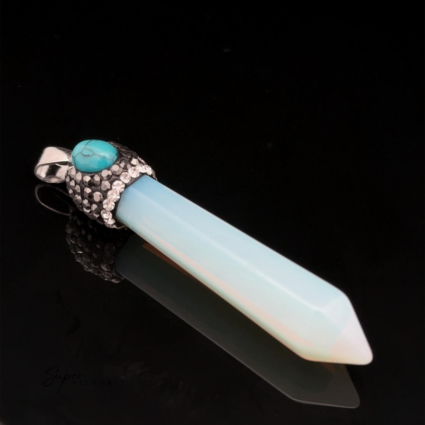 
                  
                    An Stone Obelisk Pendant featuring a pointed white and blue gemstone, topped with a decorative silver cap and a small turquoise stone, rests elegantly on a black background.

                  
                