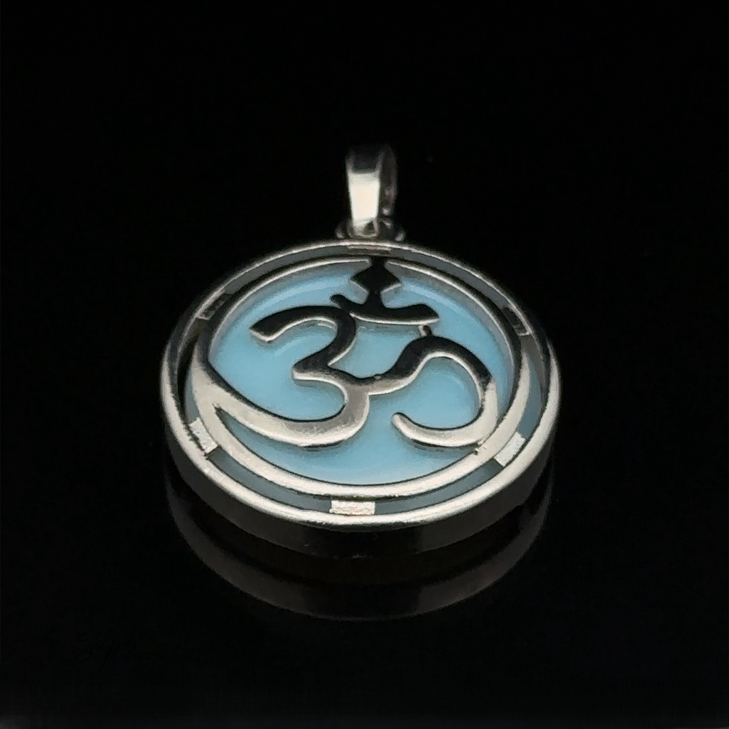 
                  
                    A round Om Pendant featuring a silver plated Om symbol on a light blue background, enhanced with opalite and set in mixed metals.
                  
                