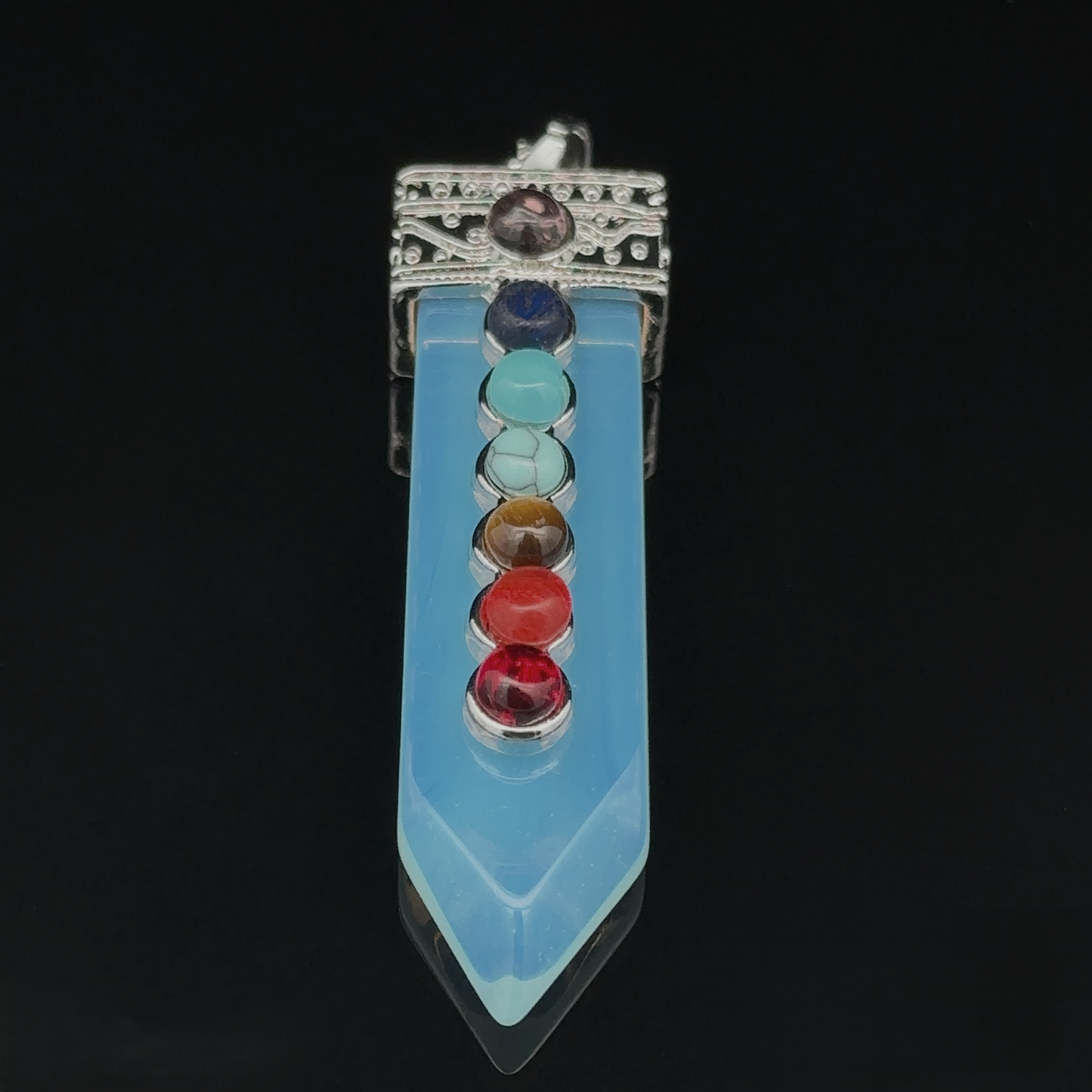 
                  
                    An Obelisk Crystal Pendant with Small Chakra Stones, with a silver-plated design, adorned with a vertical row of seven colorful chakra stones, each representing a different energy center.
                  
                