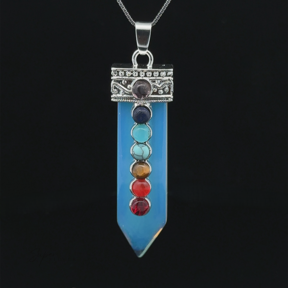 
                  
                    A stunning Obelisk Crystal Pendant with Small Chakra Stones featuring a blue crystal with seven chakra stones in a vertical line, each representing different energy centers, attached to a silver-plated design chain.
                  
                