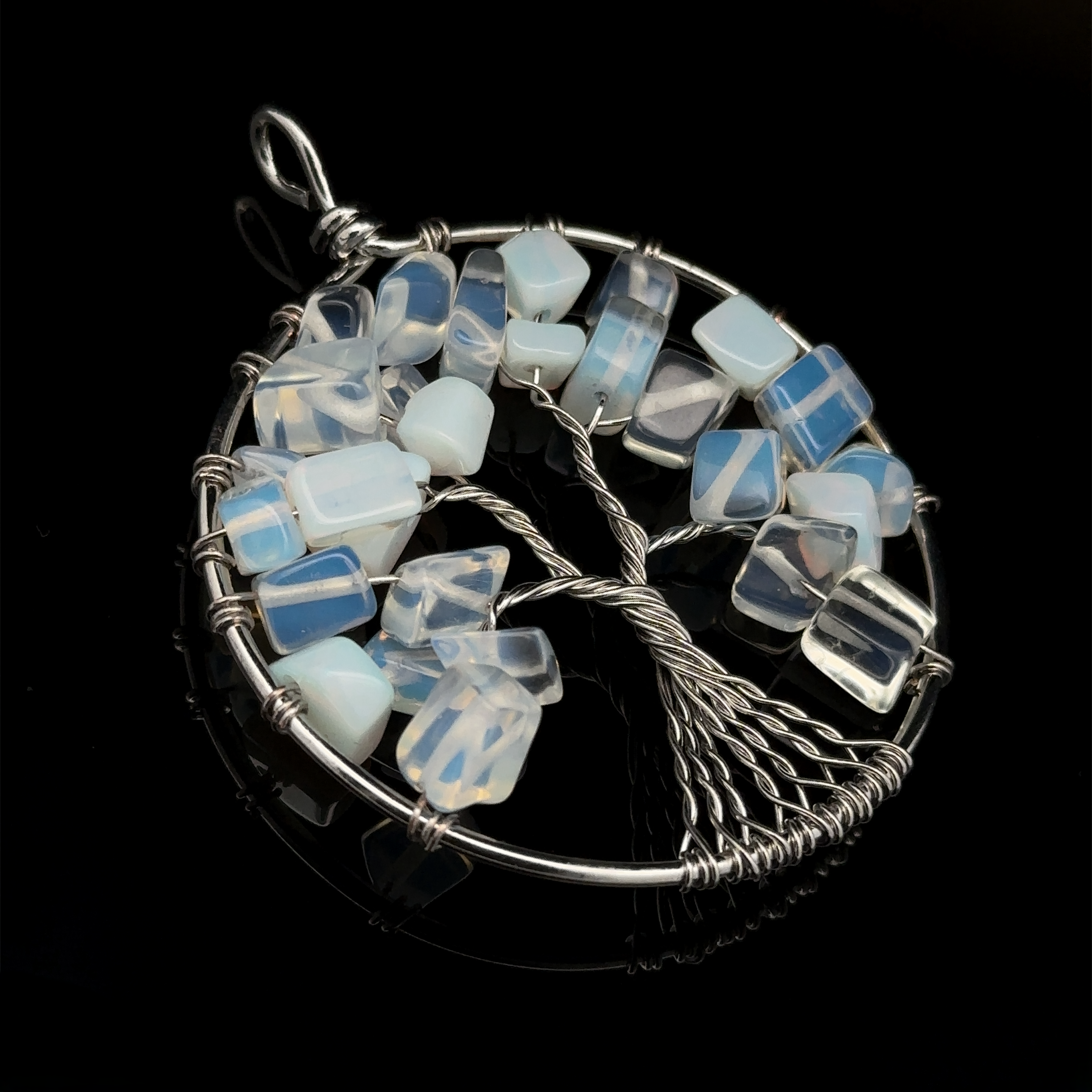 A Wire Wrapped Tree of Life Pendant, featuring mixed metals, blue and white glass cube beads, and a black background.