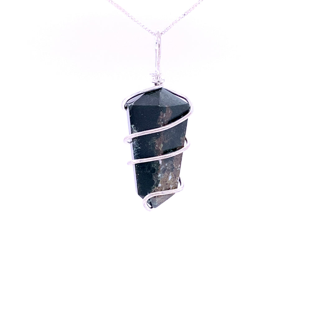 
                  
                    The Wire Wrapped Stone Pendant showcases a genuine dark crystal, intricately wrapped in mixed metals, suspended elegantly from a delicate silver chain.
                  
                