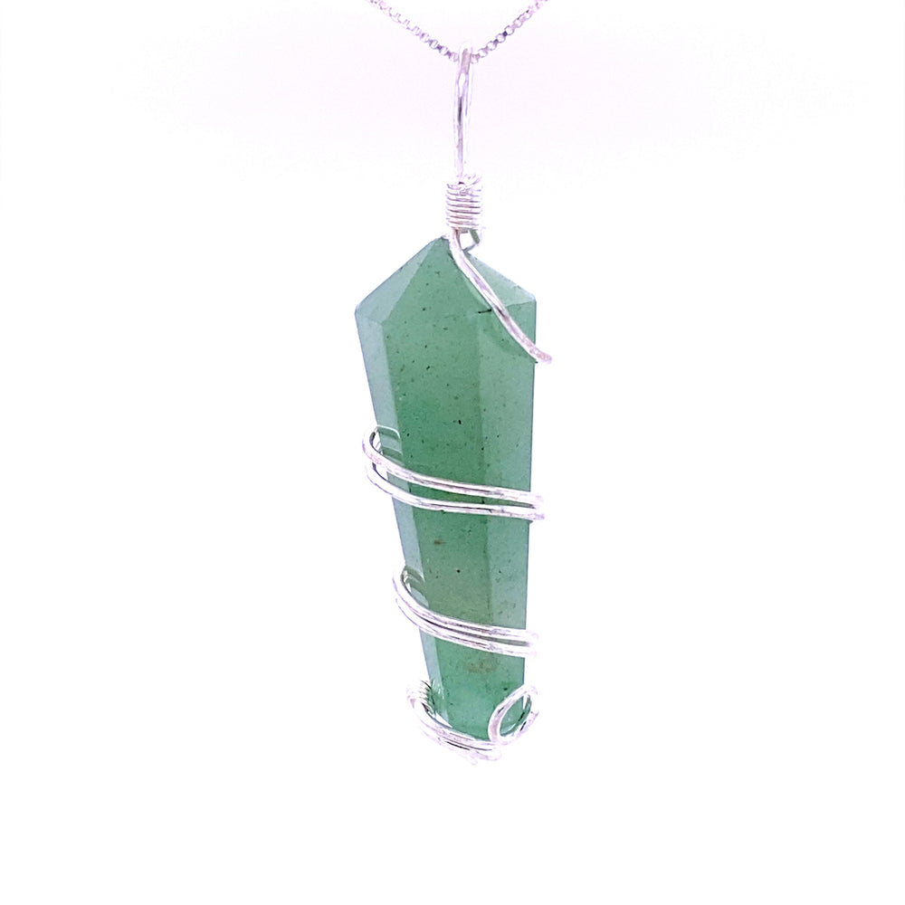 A genuine Wire Wrapped Stone Pendant, featuring a green crystal wrapped in silver wire, hangs from a silver chain against a white background.