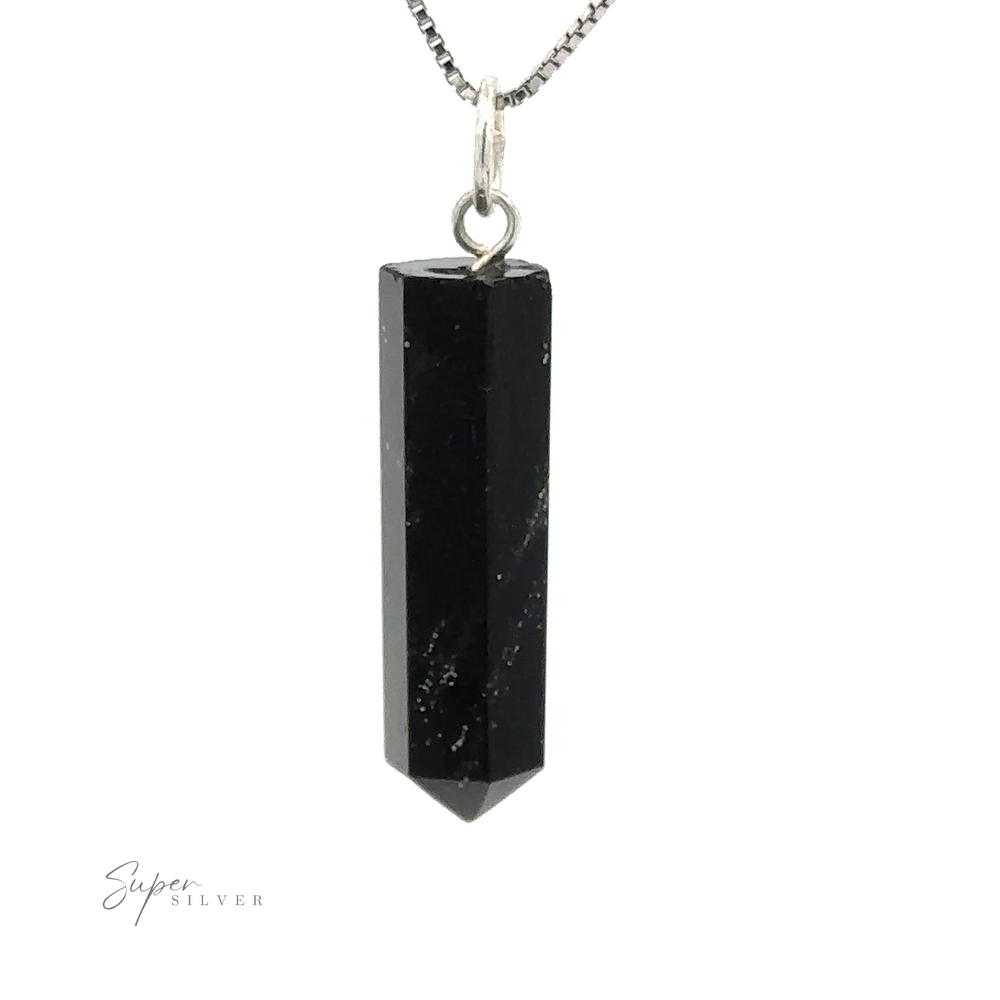 
                  
                    A black gemstone pendant with hexagonal facets, attached to a silver chain. This Raw Stone Obelisk Pendant comes to a point at the bottom and is suspended from a small metal loop.
                  
                