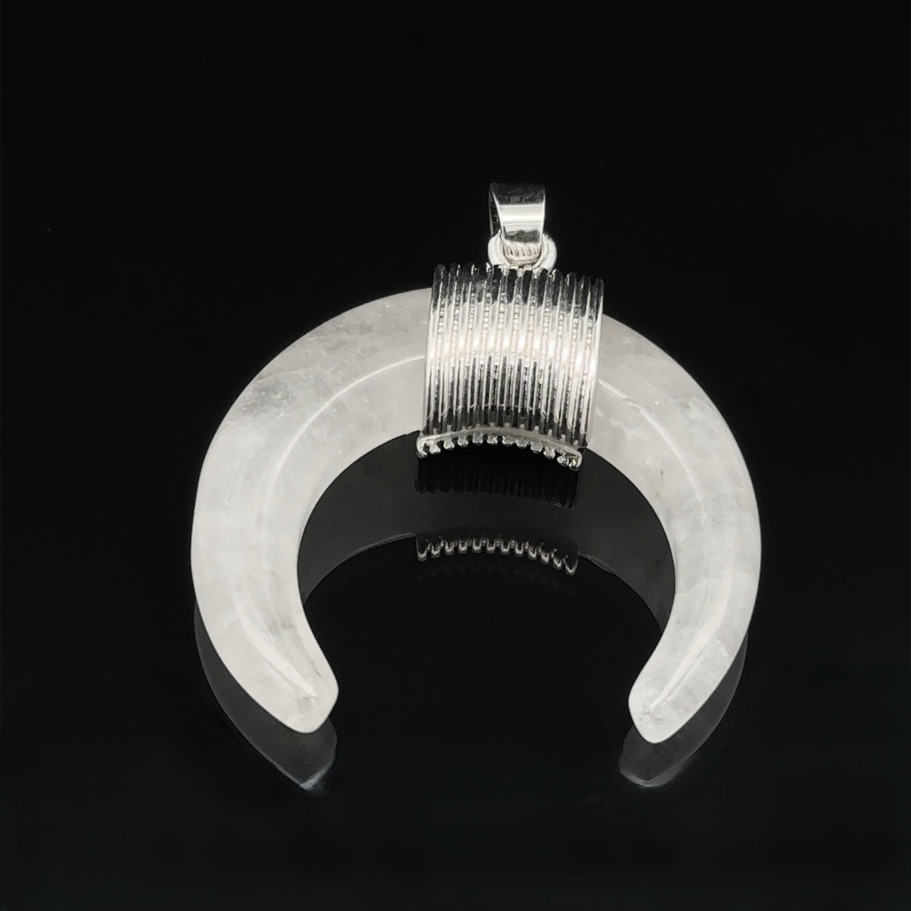 A Naja Stone Pendant with a ribbed silver top, placed on a black background.