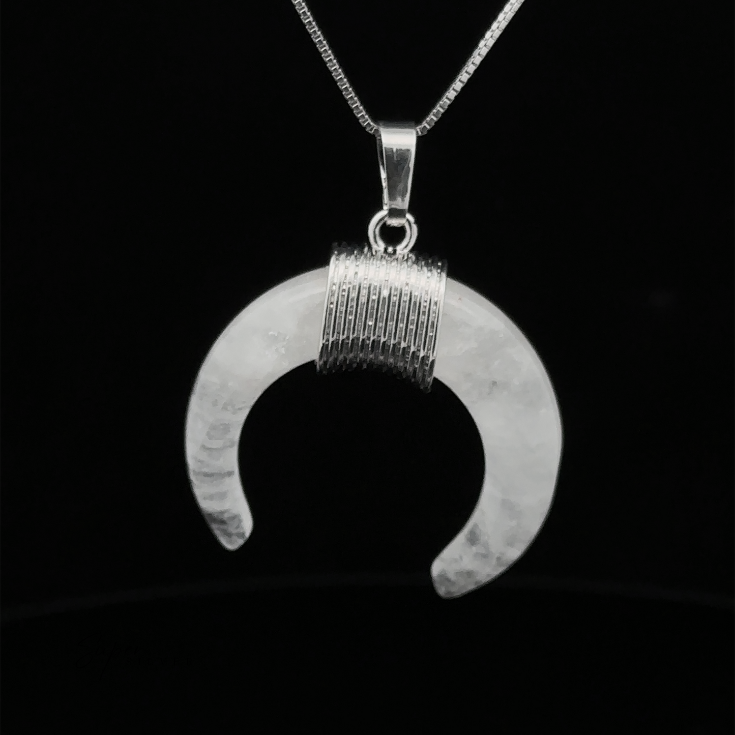 
                  
                    A Naja Stone Pendant featuring a Navajo crescent design hangs from a thin silver chain against a black background, blending traditional craftsmanship with timeless elegance.
                  
                