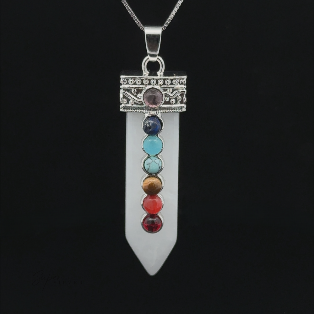 
                  
                    A stunning Obelisk Crystal Pendant with Small Chakra Stones, featuring a pointed white stone adorned with seven chakra stones vertically aligned on a decorative silver cap, set against a black background.
                  
                