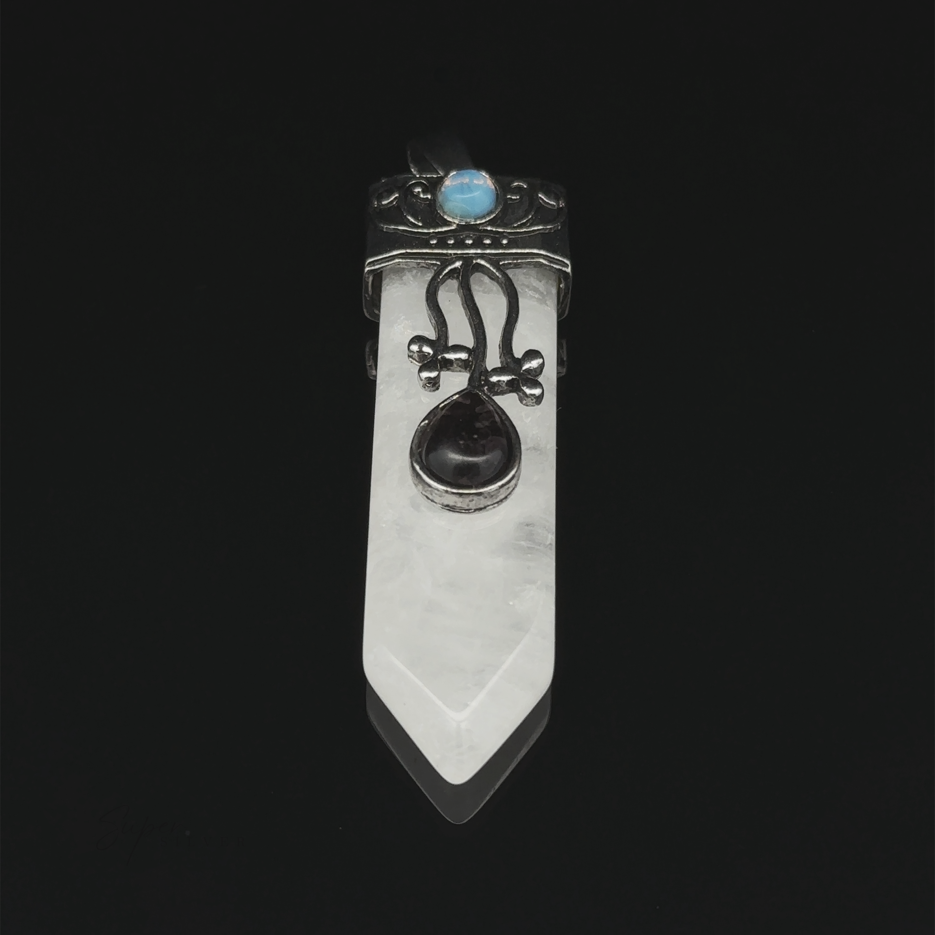 An Obelisk Crystal Stone Pendant with a silver design, featuring a pointed clear quartz and a black gemstone in the center. An opalite gemstone graces the top, all set against a black background.