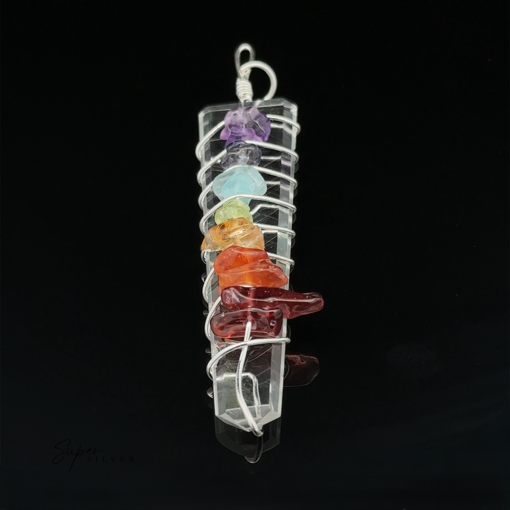
                  
                    A Stone Slab Wire-Wrapped Chakra Pendant featuring a vertically aligned clear crystal wrapped in silver wire, adorned with seven chakra stones, creating an exquisite example of crystal pendants.
                  
                