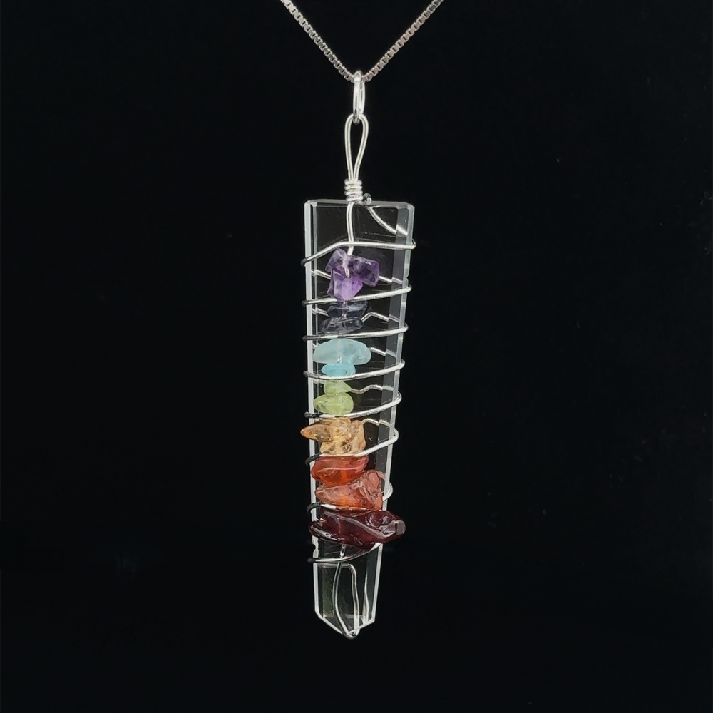 
                  
                    Stone Slab Wire-Wrapped Chakra Pendant containing colorful chakra stones, including purple, blue, green, yellow, orange, and red, against a black background.
                  
                
