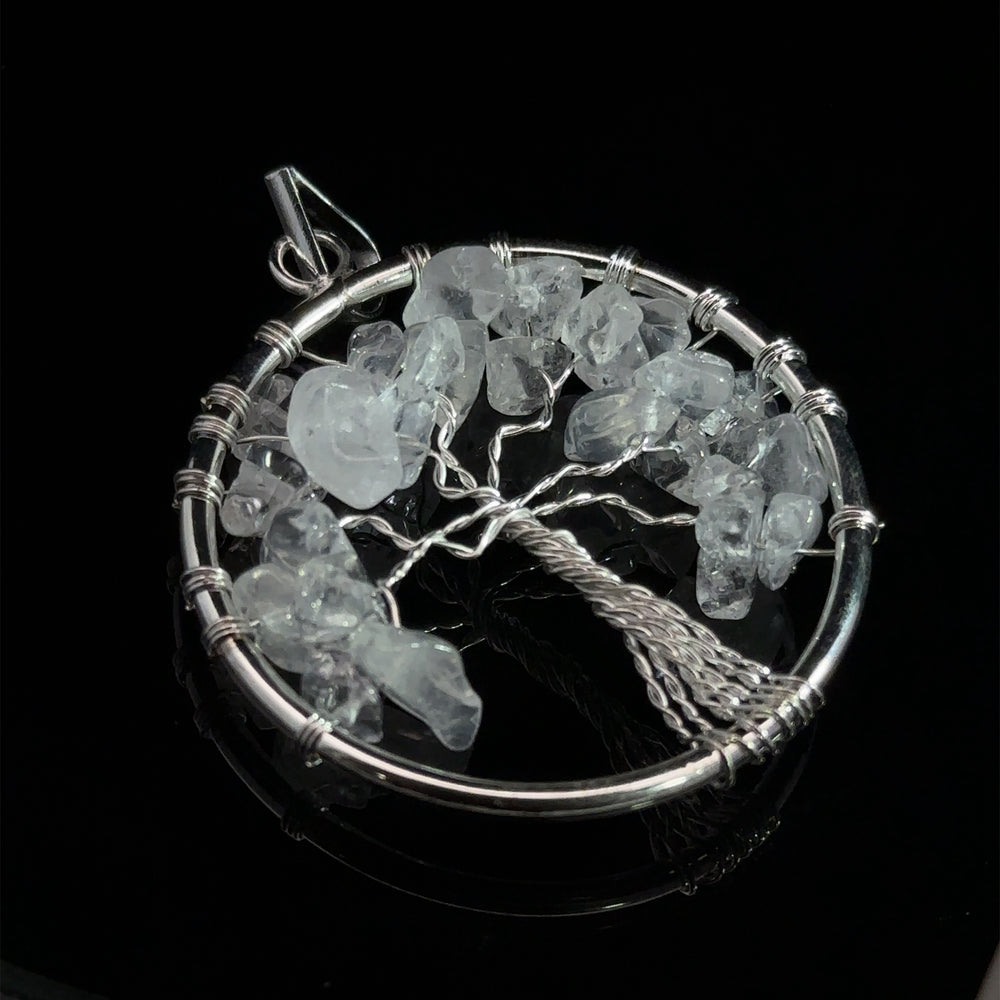 
                  
                    A Wire Wrapped Tree of Life Pendant with Stones featuring a wire-wrapped tree design with translucent gemstones, set against a black background.
                  
                