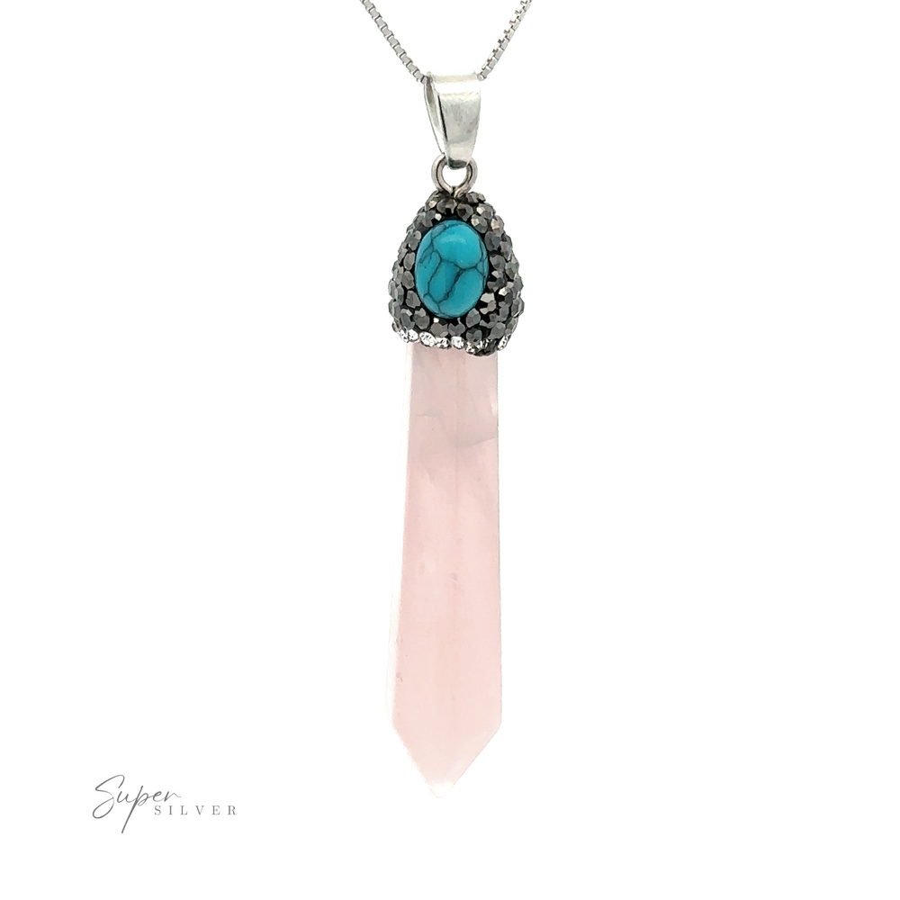
                  
                    A long Stone Obelisk Pendant with a pink crystal and turquoise stone set in silver at the top, accented with hematite beads, hanging from a thin silver chain.
                  
                
