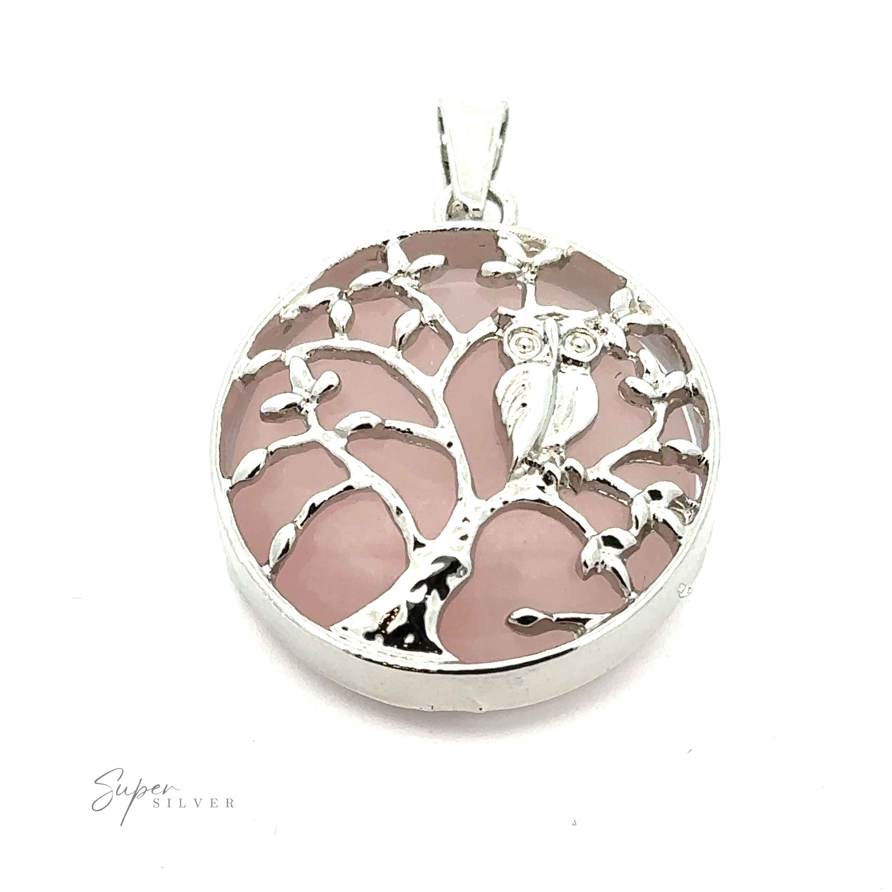 A silver round **Owl and Tree Pendant** featuring an intricate tree design with an owl, accented by dazzling mixed metals, set against a pink background.