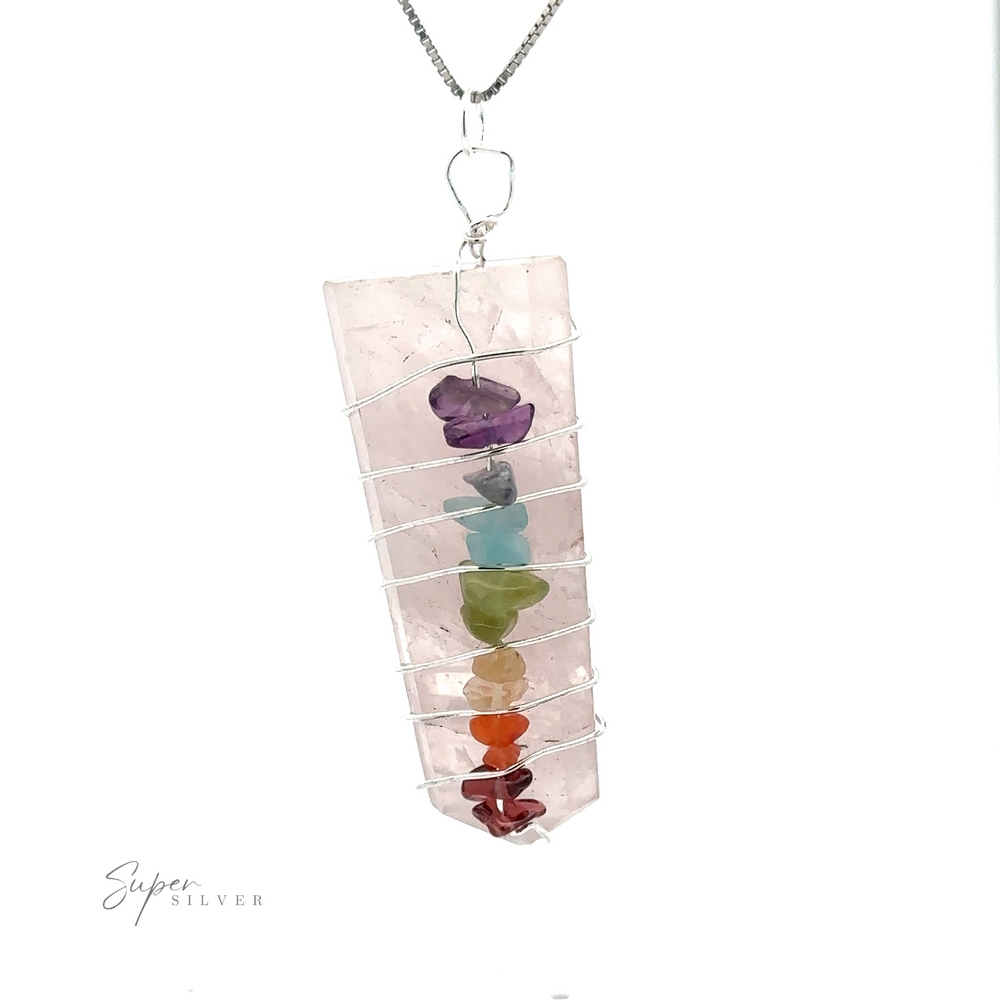 
                  
                    A Stone Slab Wire-Wrapped Chakra Pendant with a rectangular pink gemstone slab wrapped in silver wire, featuring seven small chakra stones running vertically along the wire. The pendant is attached to a silver chain.
                  
                