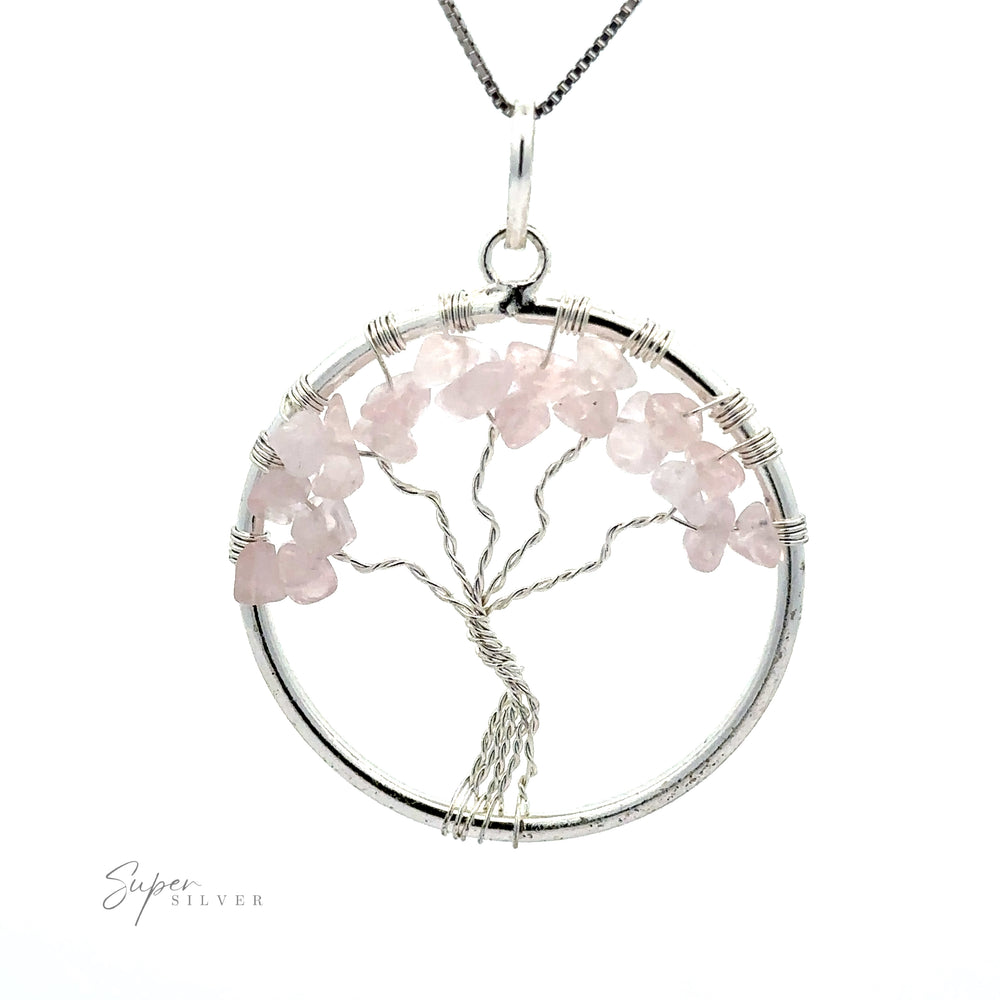 
                  
                    A circular silver pendant, named "Wire Wrapped Tree of Life Pendant with Stones," features a Tree of Life design made of pink gemstones and intricately wire wrapped. The pendant is attached to a silver chain, with the brand name "Super Silver" visible in the bottom left corner.
                  
                