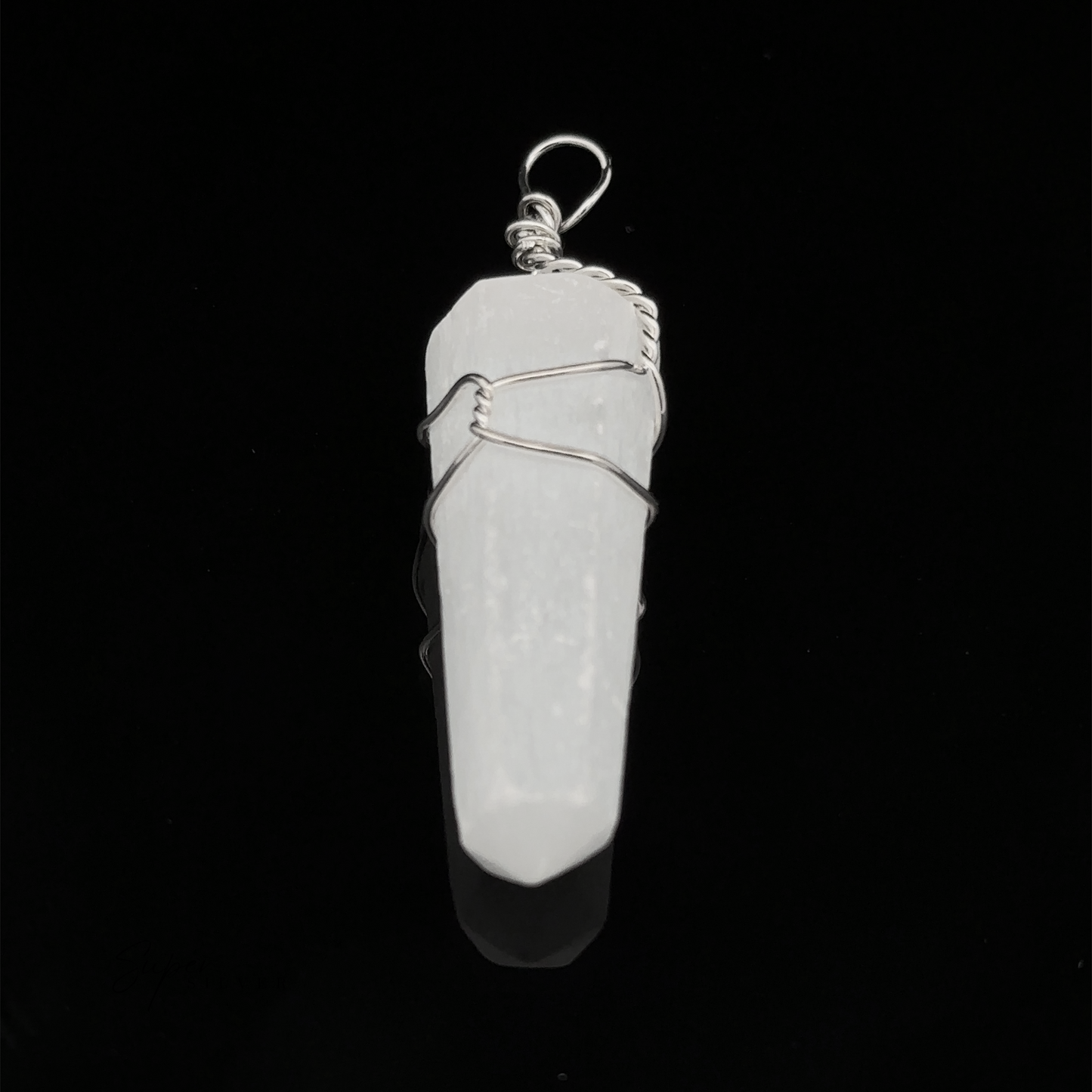 
                  
                    A white crystal Wire Wrapped Stone Pendant, placed on a black background, exuding the elegance akin to a finely cut quartz.
                  
                