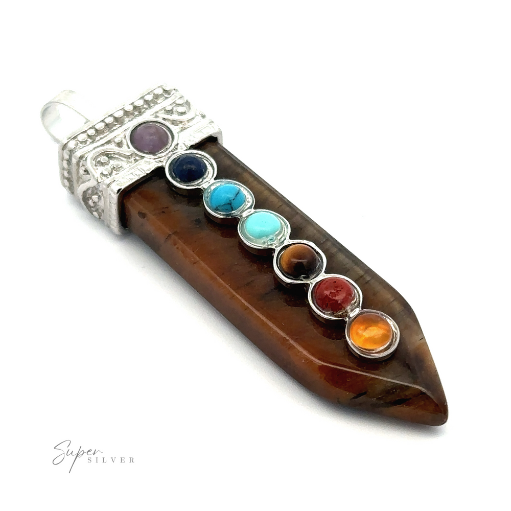 
                  
                    A Obelisk Crystal Pendant with Small Chakra Stones adorned with seven small, colorful chakra stones and a silver decorative cap with a bail for hanging. The brand "Super Silver" is visible in the bottom left corner.
                  
                