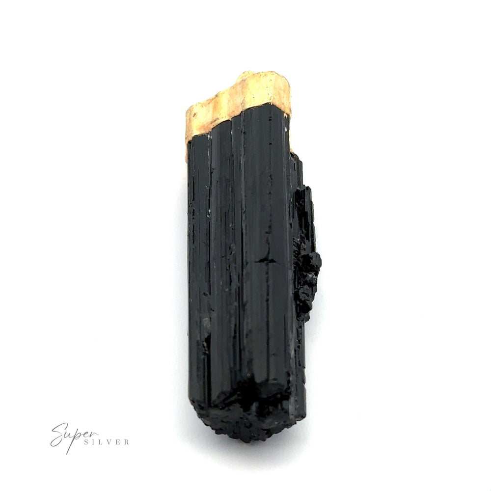
                  
                    A black, columnar crystal of schorl tourmaline with a beige tip is displayed against a white background. This Raw Crystal Pendant With Gold Cap has grooved surfaces and a glossy finish. The text "Super Silver" is visible in the corner.
                  
                