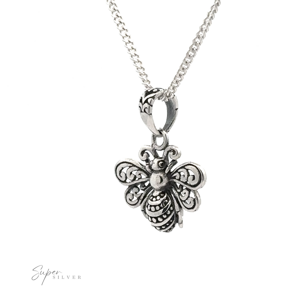 
                  
                    Close-up of the Filigree Bee Pendant on a chain necklace, crafted in .925 Sterling Silver with intricate detailing, set against a plain white background. This artisan jewelry piece is a delicate marvel.
                  
                