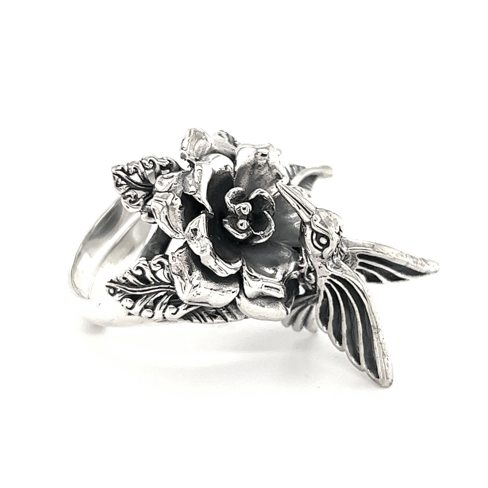 An adjustable silver Hummingbird with Flower Ring featuring a hummingbird perched amidst delicate flowers.