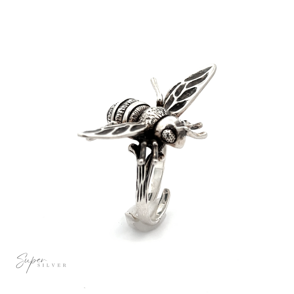 
                  
                    A detailed Large Bee Ring featuring a handcrafted honey bee with open wings on top. The adjustable size band ensures a perfect fit. The ring is shown on a white background, with "Super Silver" written in the bottom left corner.
                  
                