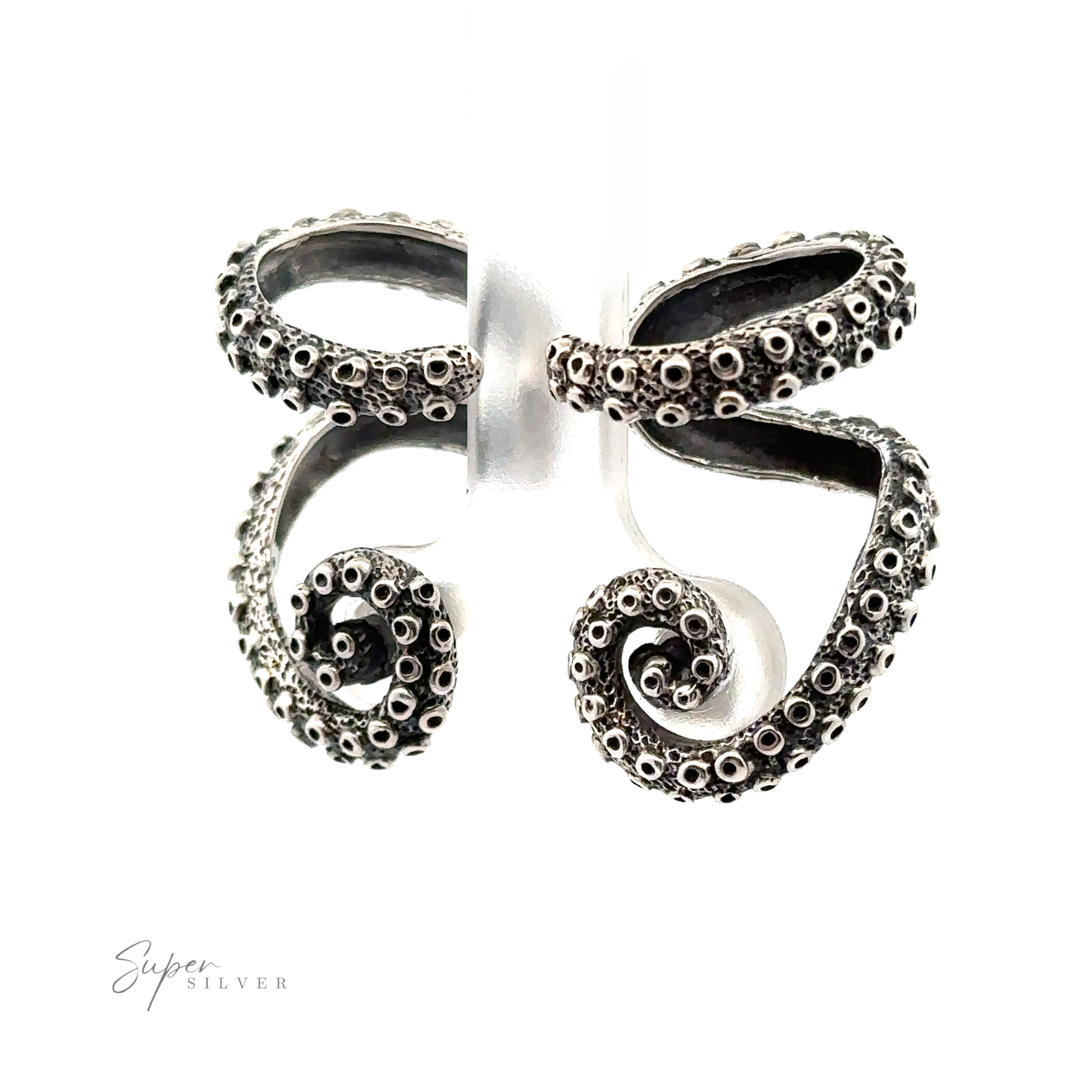 A pair of Curled Tentacle Earrings designed to resemble two intertwined octopus tentacles, with detailed suckers along the curves. This piece from Ocean Allure Jewelry showcases handcrafted sterling silver artistry. The brand name "Super Silver" is visible in the bottom left corner.