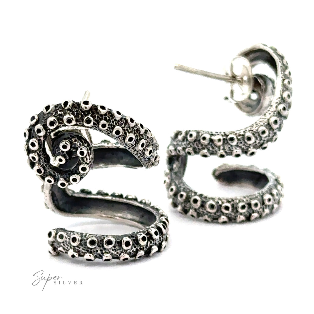 A pair of Curled Tentacle Earrings designed to resemble octopus tentacles with intricate details, these handcrafted sterling silver pieces are displayed on a clean white background, capturing the essence of ocean allure jewelry.