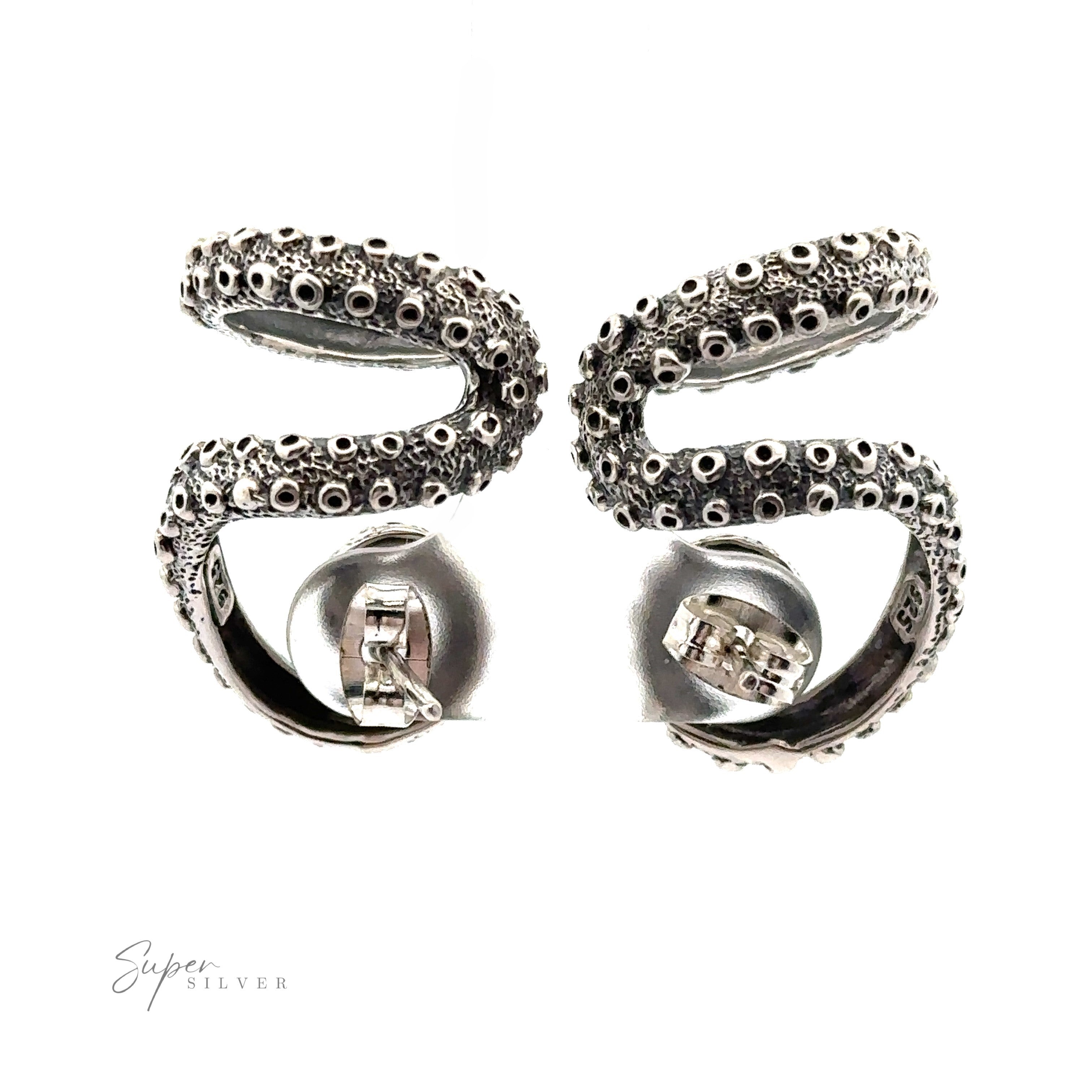 A pair of handcrafted sterling silver earrings designed to resemble octopus tentacles, featuring detailed suction cups and a polished finish. The brand name "Super Silver" is located in the bottom left corner. These Curled Tentacle Earrings embody true ocean allure jewelry style.