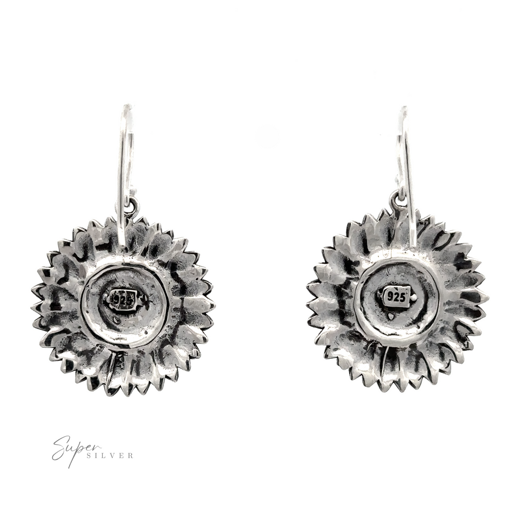 
                  
                    Pair of silver sunflower earrings with embossed details and center hallmark stamps, displayed against a white background.
                  
                