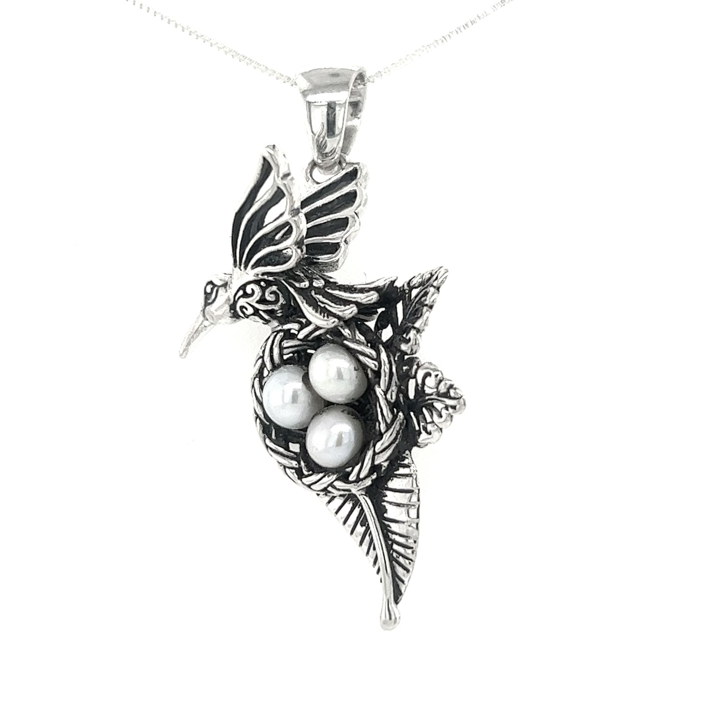 
                  
                    A Hummingbird Pendant with Nest of Pearls by Super Silver on a silver chain.
                  
                