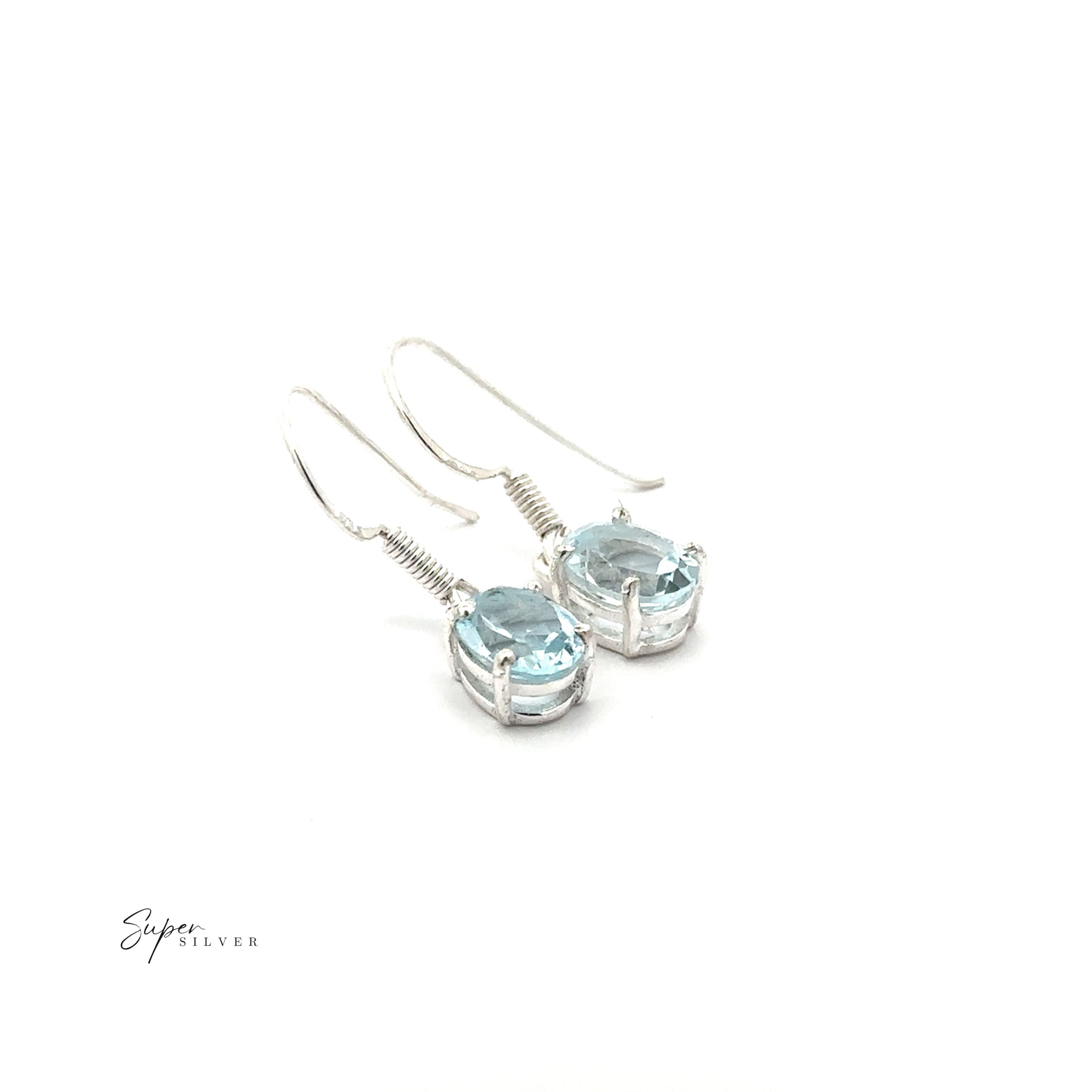 Brilliant Oval Gemstone Earrings: Sterling silver prong-set earrings with light blue oval gemstones and simple hooks, shown on a white background with the “Super Silver” logo in the corner.