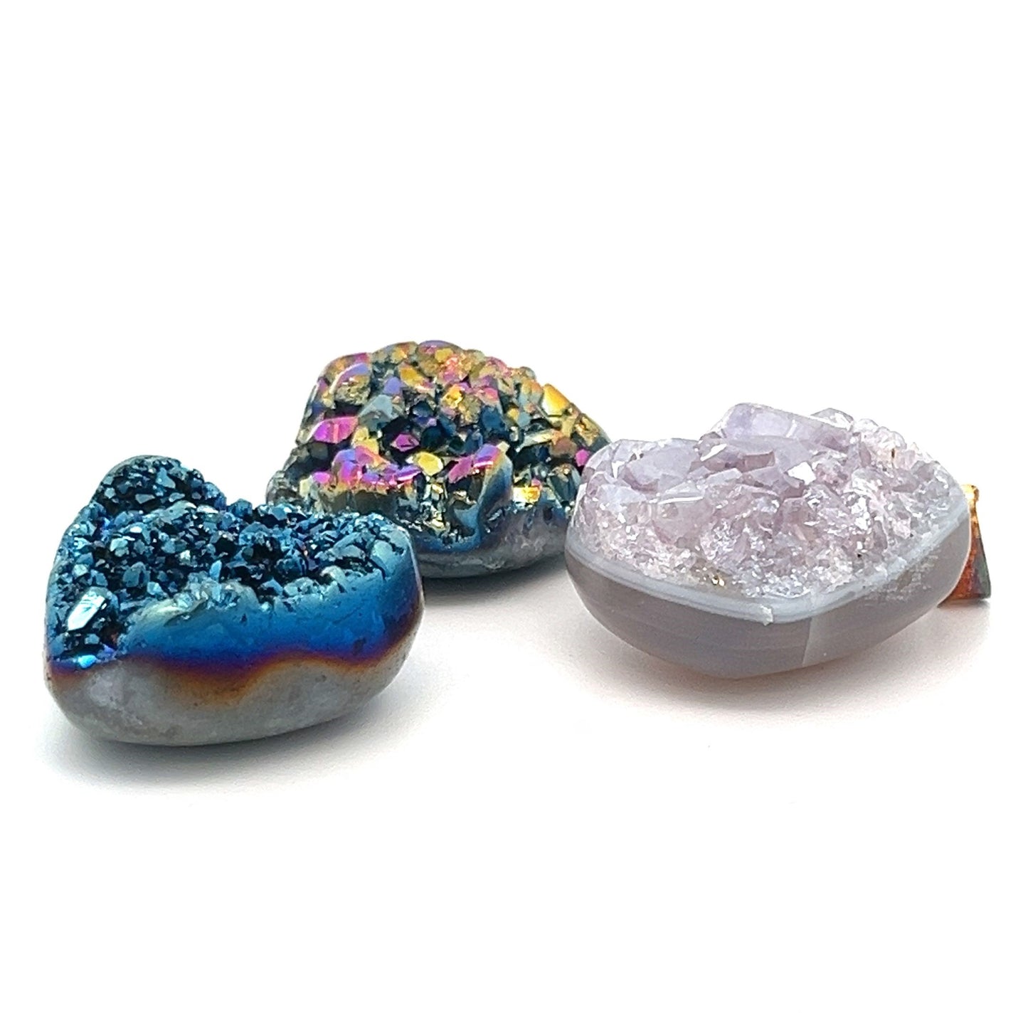 
                  
                    The Dazzling Druzy Pendant collection includes three distinctive geode stones: a blue one adorned with crystal formations, a purple one featuring a white base, and a multicolored one showcasing an array of shades. Each pendant is elegantly finished with a gold-plated bail for an extra touch of sophistication.
                  
                